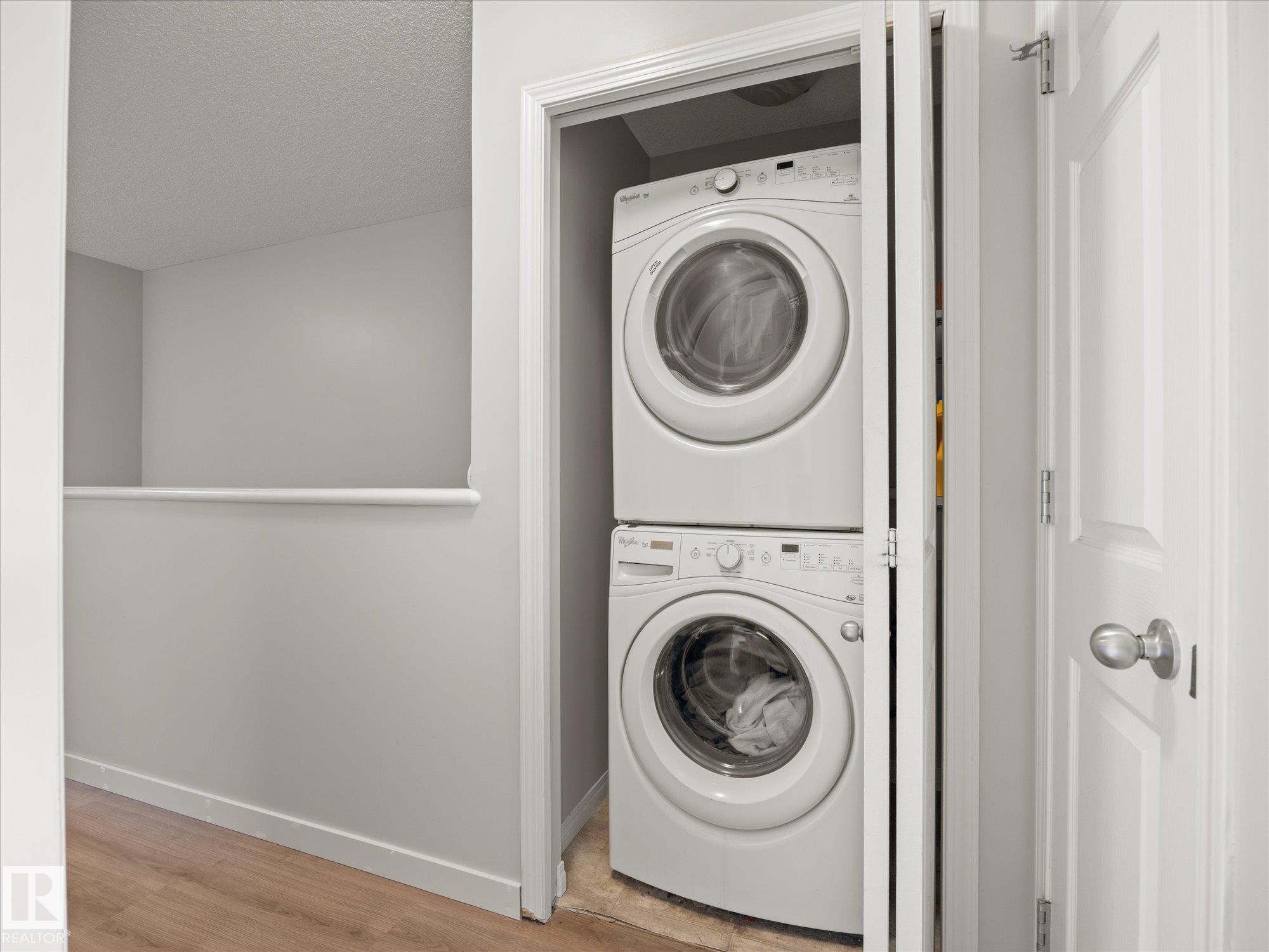 Stackable washer and dryer unit within a dedicated closet - 473 Orchards Boulevard Sw, Edmonton, AB - Indoor Photo Showing Laundry Room