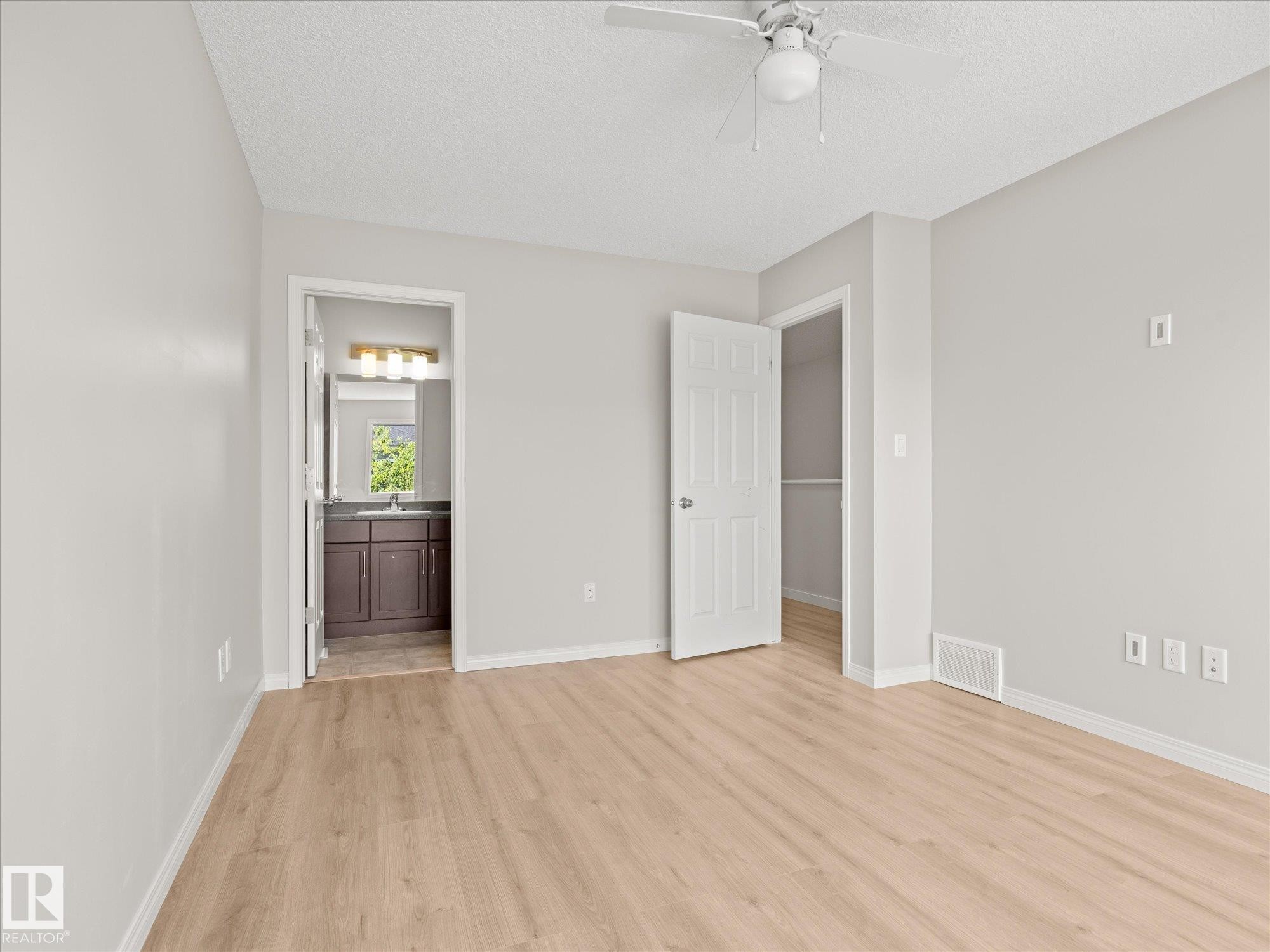 Spacious room featuring light wood-finish flooring, neutral wall tones, and a ceiling fan with light fixture - 473 Orchards Boulevard Sw, Edmonton, AB - Indoor Photo Showing Other Room