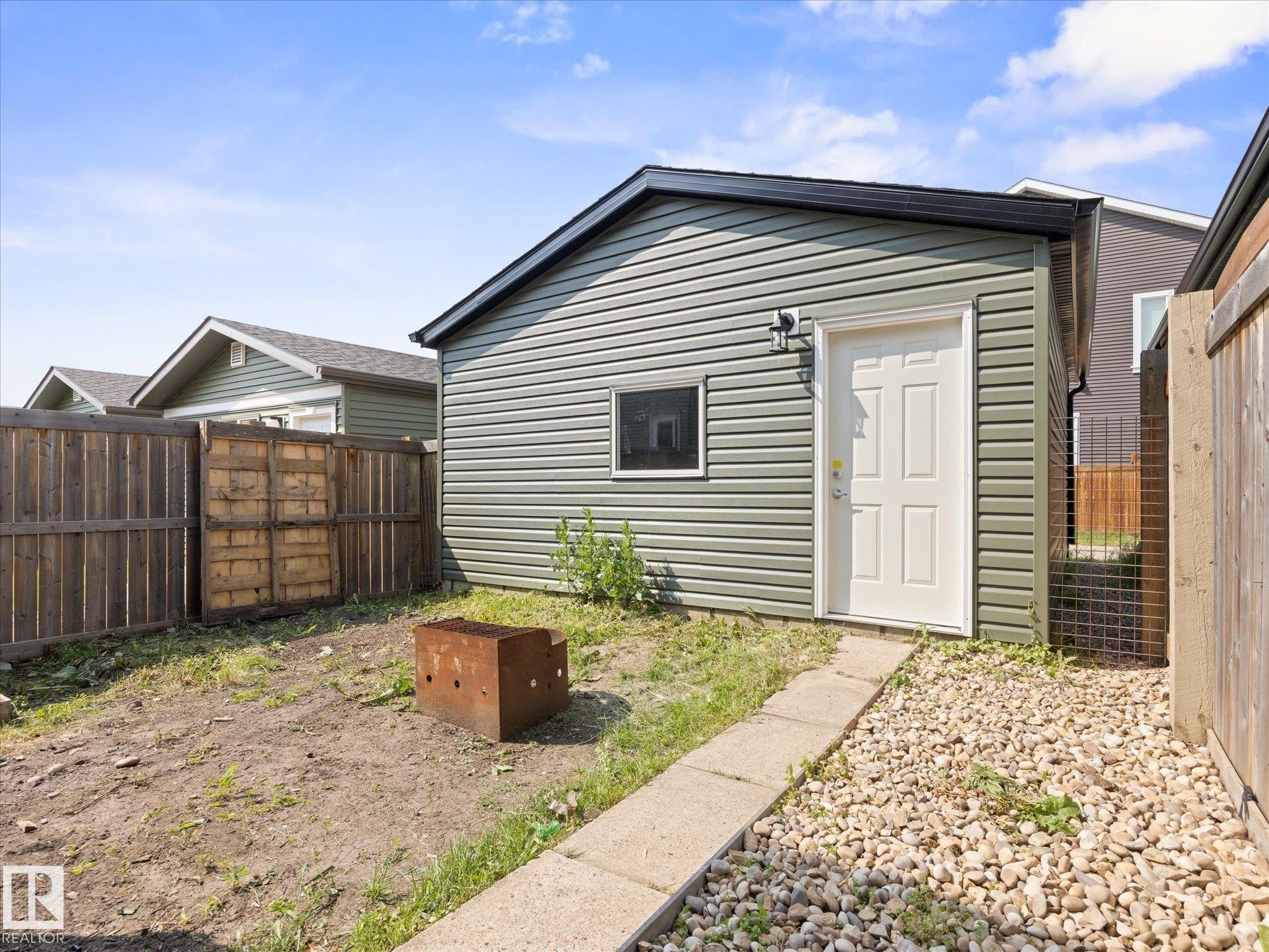 Detached ancillary building featuring horizontal siding and a dark shingled roof - 473 Orchards Boulevard Sw, Edmonton, AB - Outdoor
