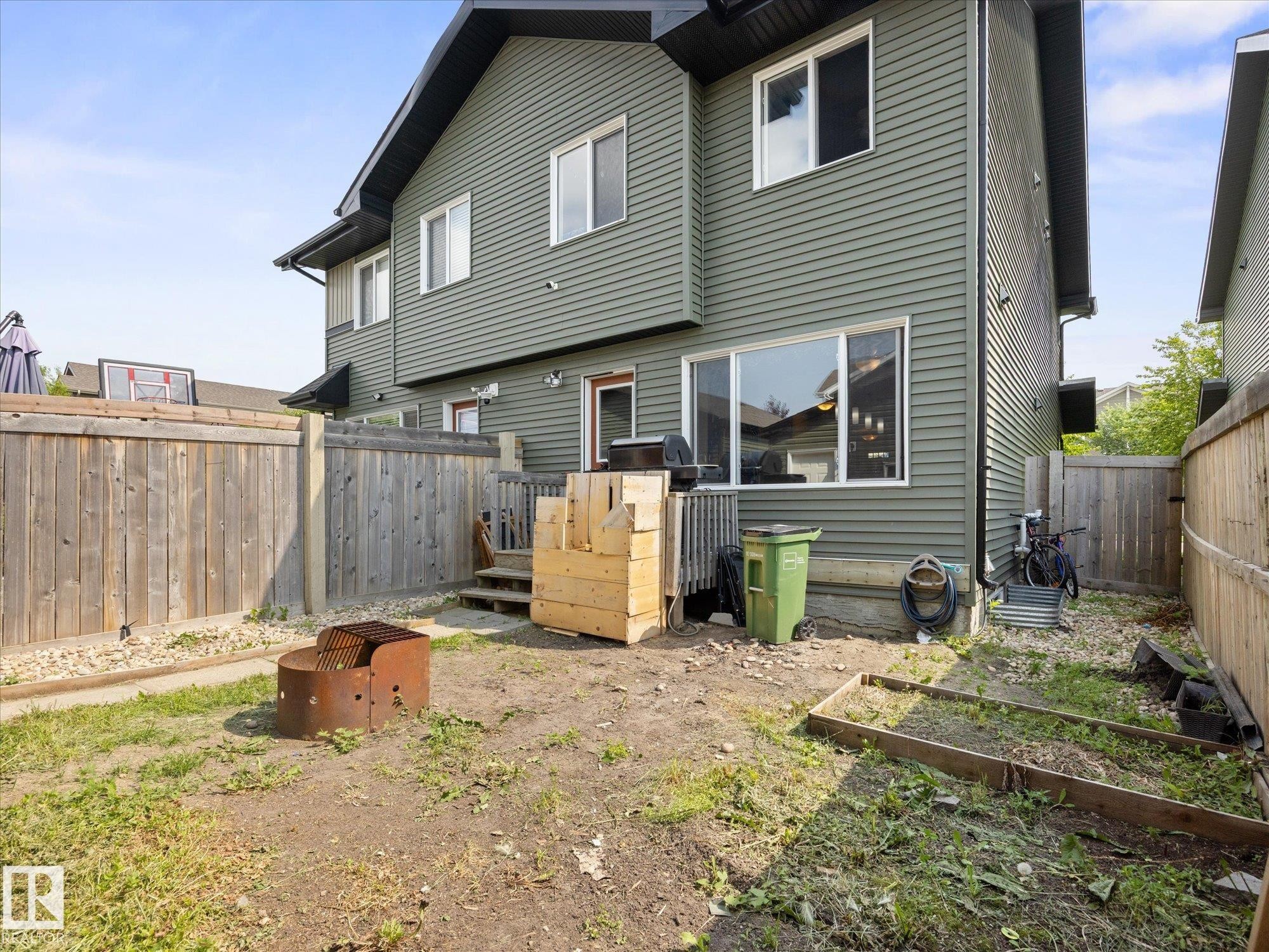 Rear exterior featuring horizontal siding in a muted green hue - 473 Orchards Boulevard Sw, Edmonton, AB - Outdoor With Exterior