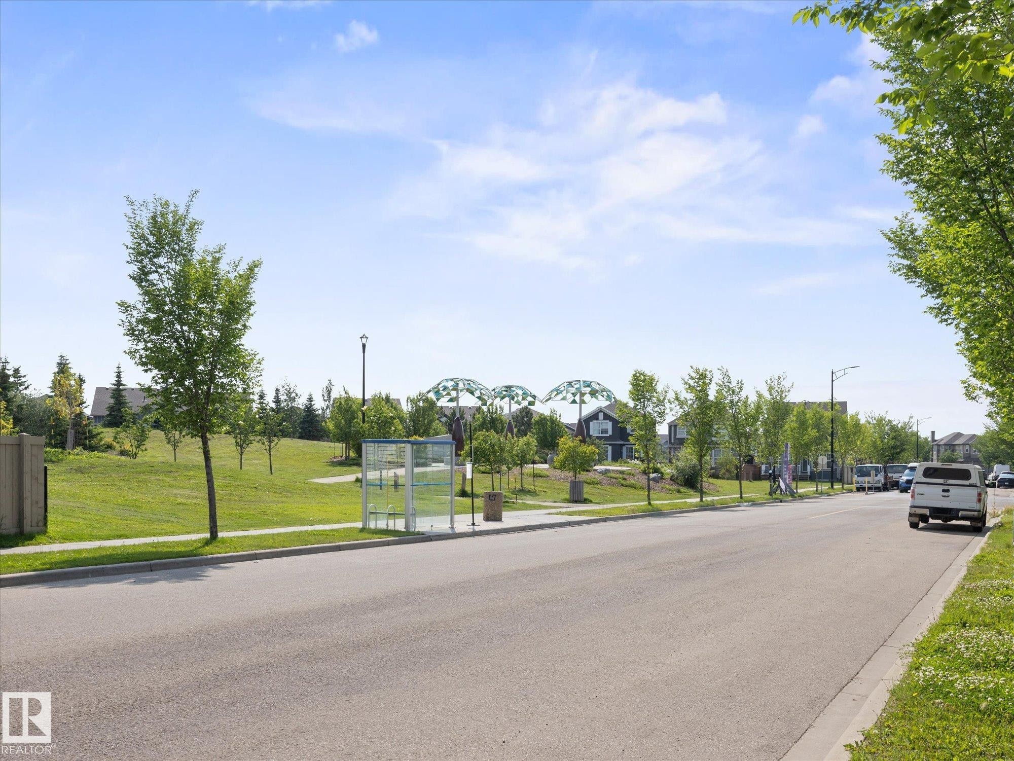 Tree-lined street with a manicured grassy park area - 473 Orchards Boulevard Sw, Edmonton, AB - Outdoor With View