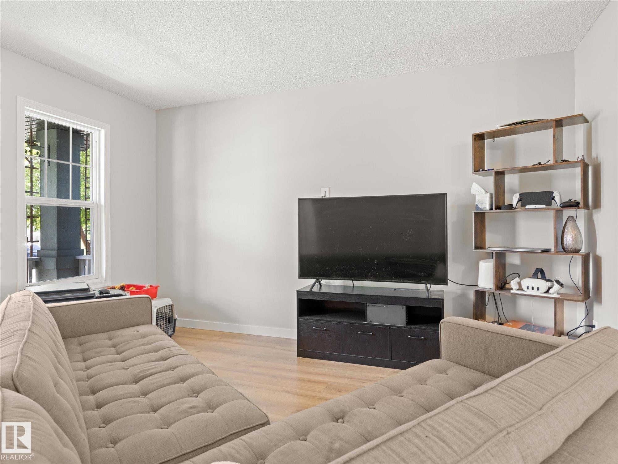 Living area featuring light wood-finish flooring and a neutral color palette - 473 Orchards Boulevard Sw, Edmonton, AB - Indoor Photo Showing Living Room