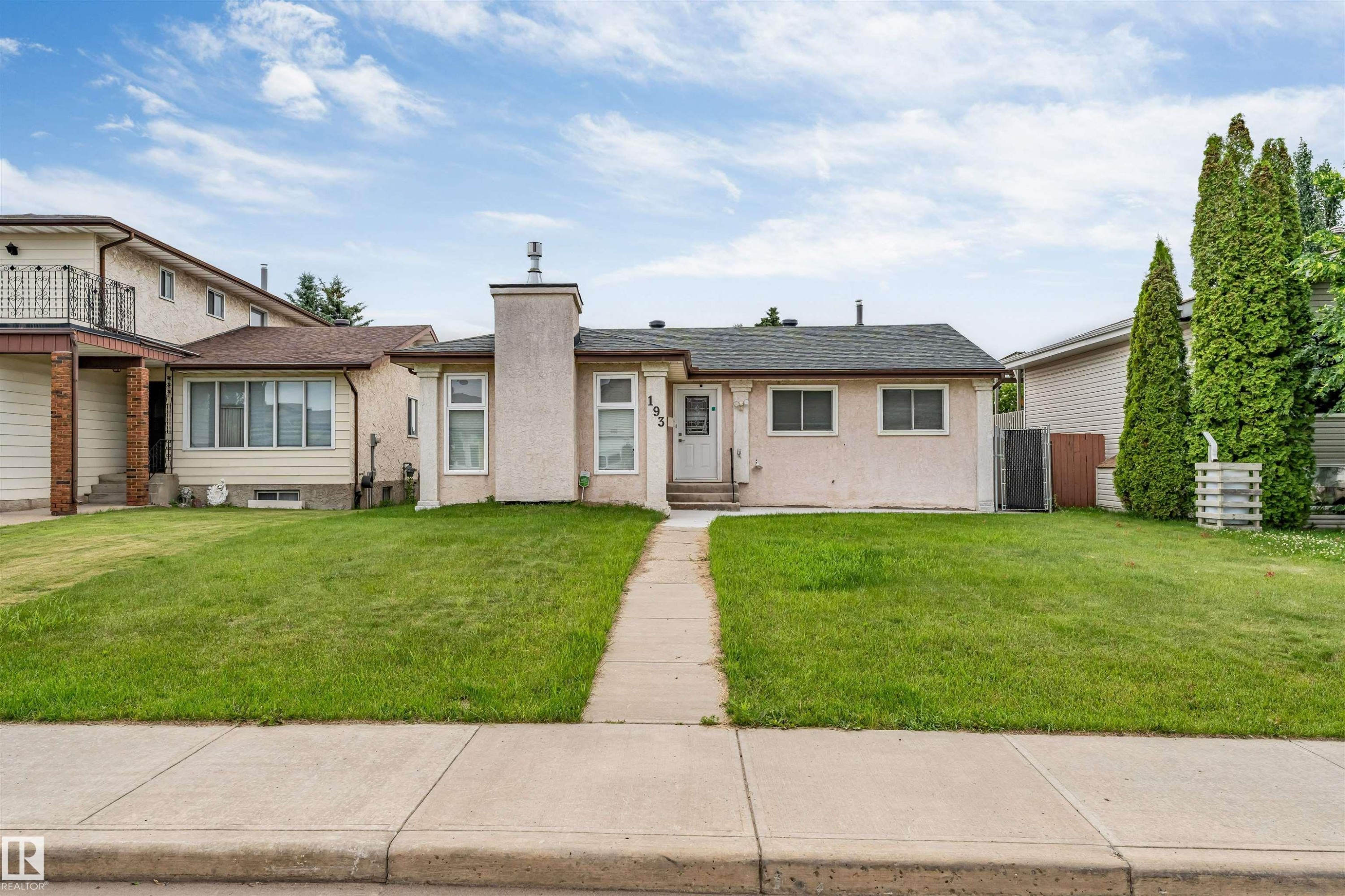 Exterior featuring a stucco facade, central entryway, and a chimney structure - 193 Woodvale Road W, Edmonton, AB