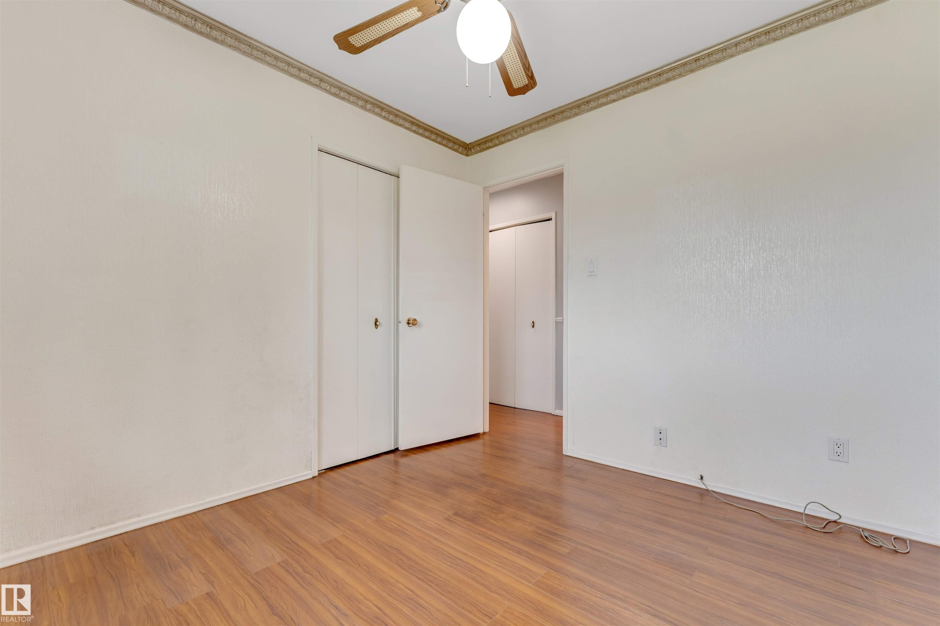 Room with wood-finish flooring, ceiling fan with light, and crown molding - 193 Woodvale Road W, Edmonton, AB