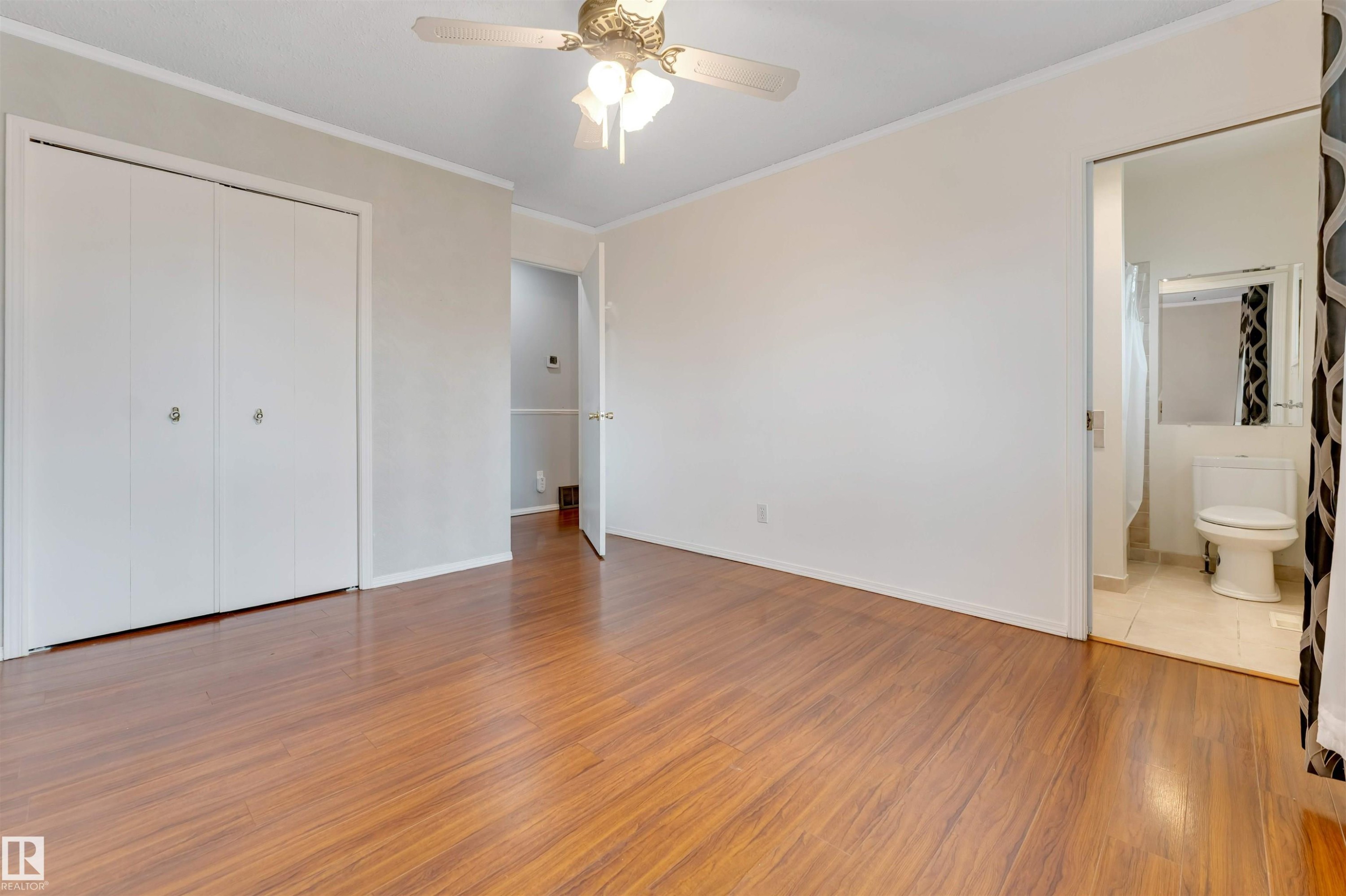 Spacious room featuring wood-finish flooring, white walls, and bright overhead lighting - 193 Woodvale Road W, Edmonton, AB