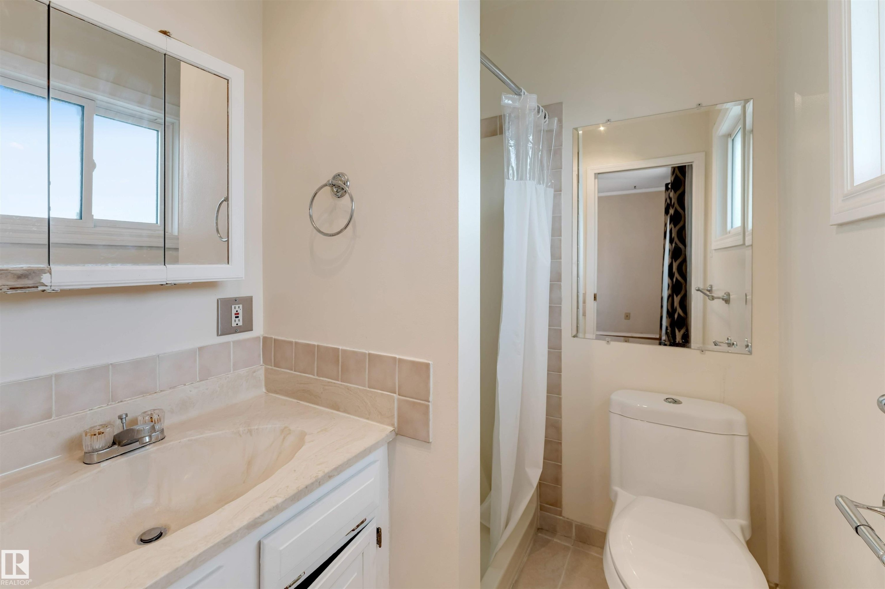 Bathroom featuring a white vanity with integrated sink, tiled backsplash, and medicine cabinet - 193 Woodvale Road W, Edmonton, AB