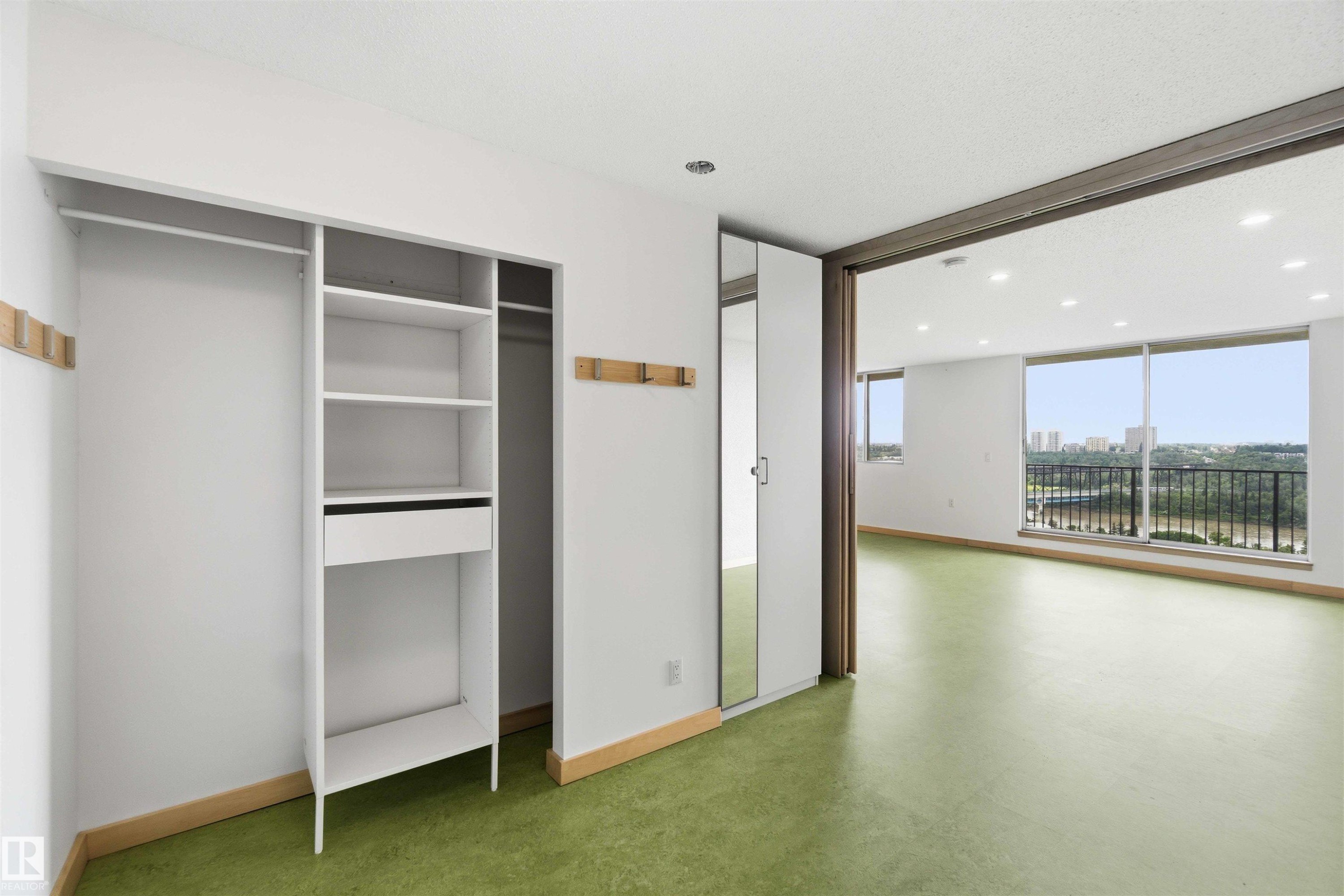 Built-in closet system with shelving and hanging rods, complemented by a full-length mirrored door - #1008 11307 99 Av Nw, Edmonton, AB