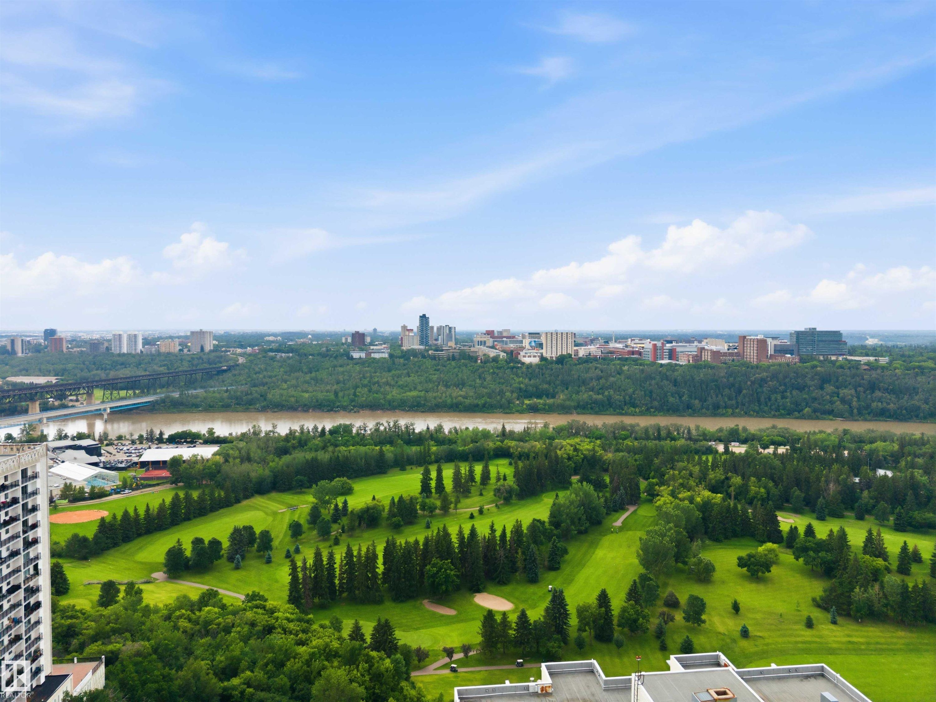 Expansive golf course and river views, featuring a distant cityscape - #1008 11307 99 Av Nw, Edmonton, AB