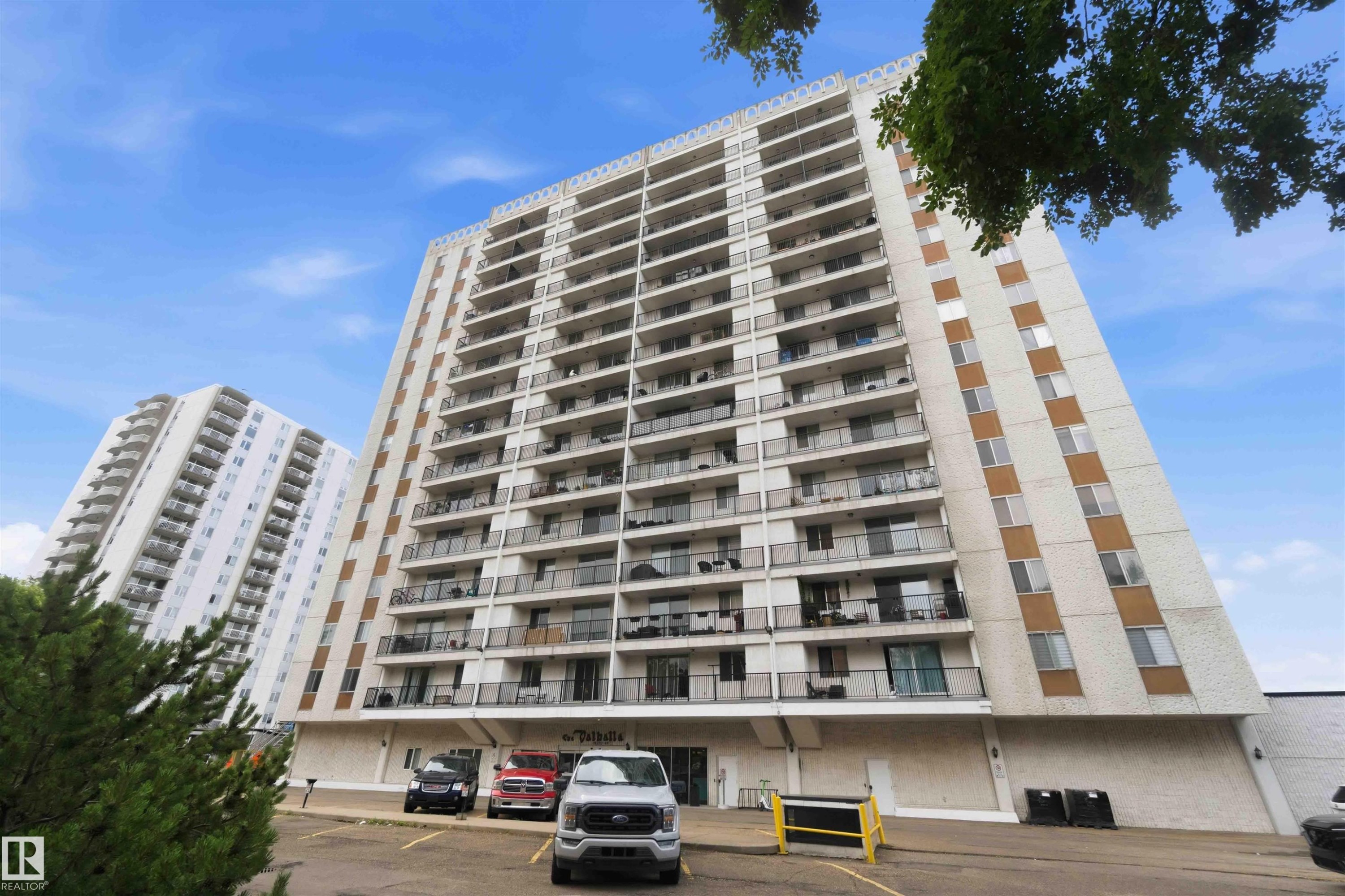 Mid-rise tower featuring multiple balconies, a white exterior, and brown accent panels - #1008 11307 99 Av Nw, Edmonton, AB