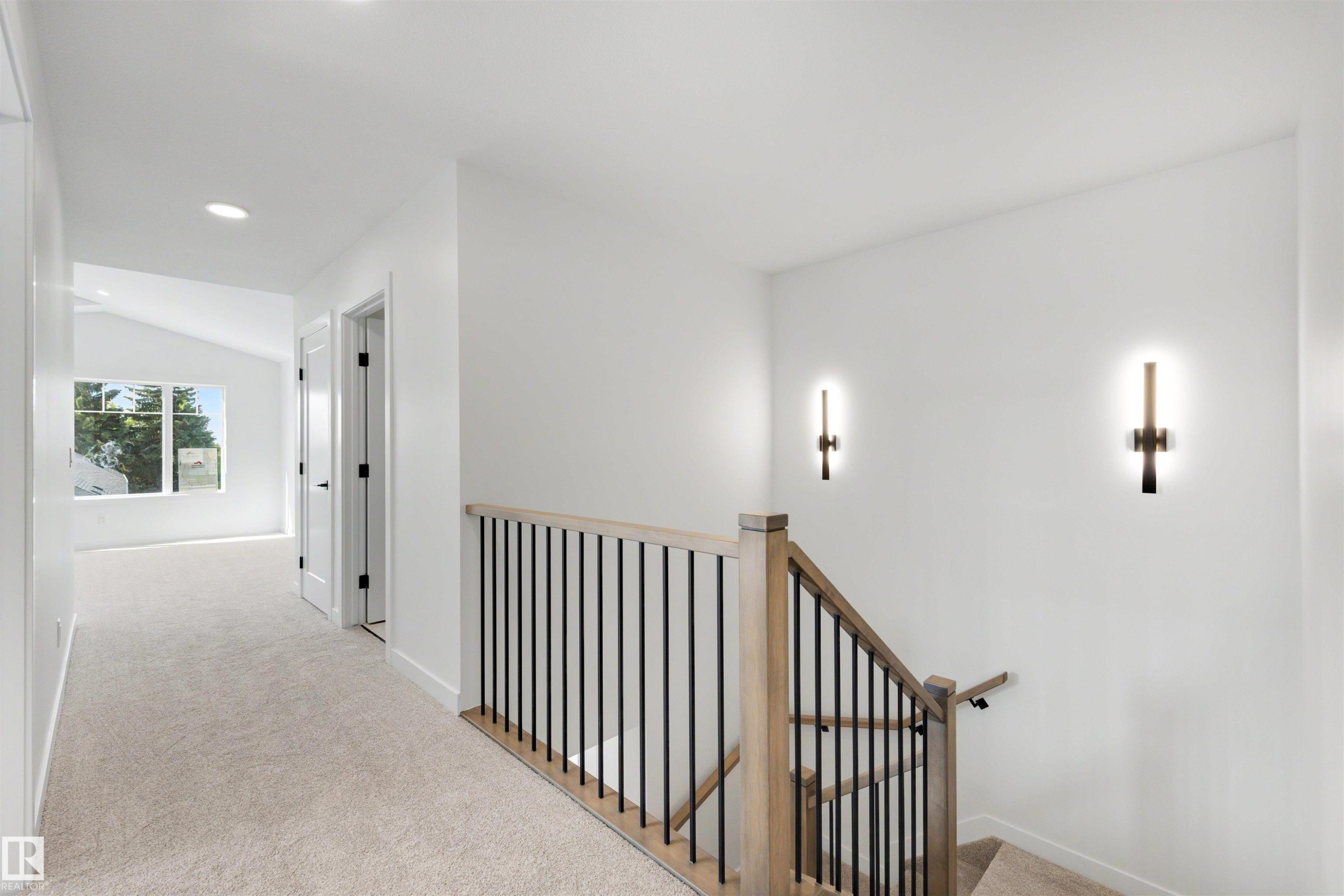 Carpeted hallway featuring a vaulted ceiling, recessed lighting, and a window providing natural illumination - 30 Elsinore Place Nw, Edmonton, AB