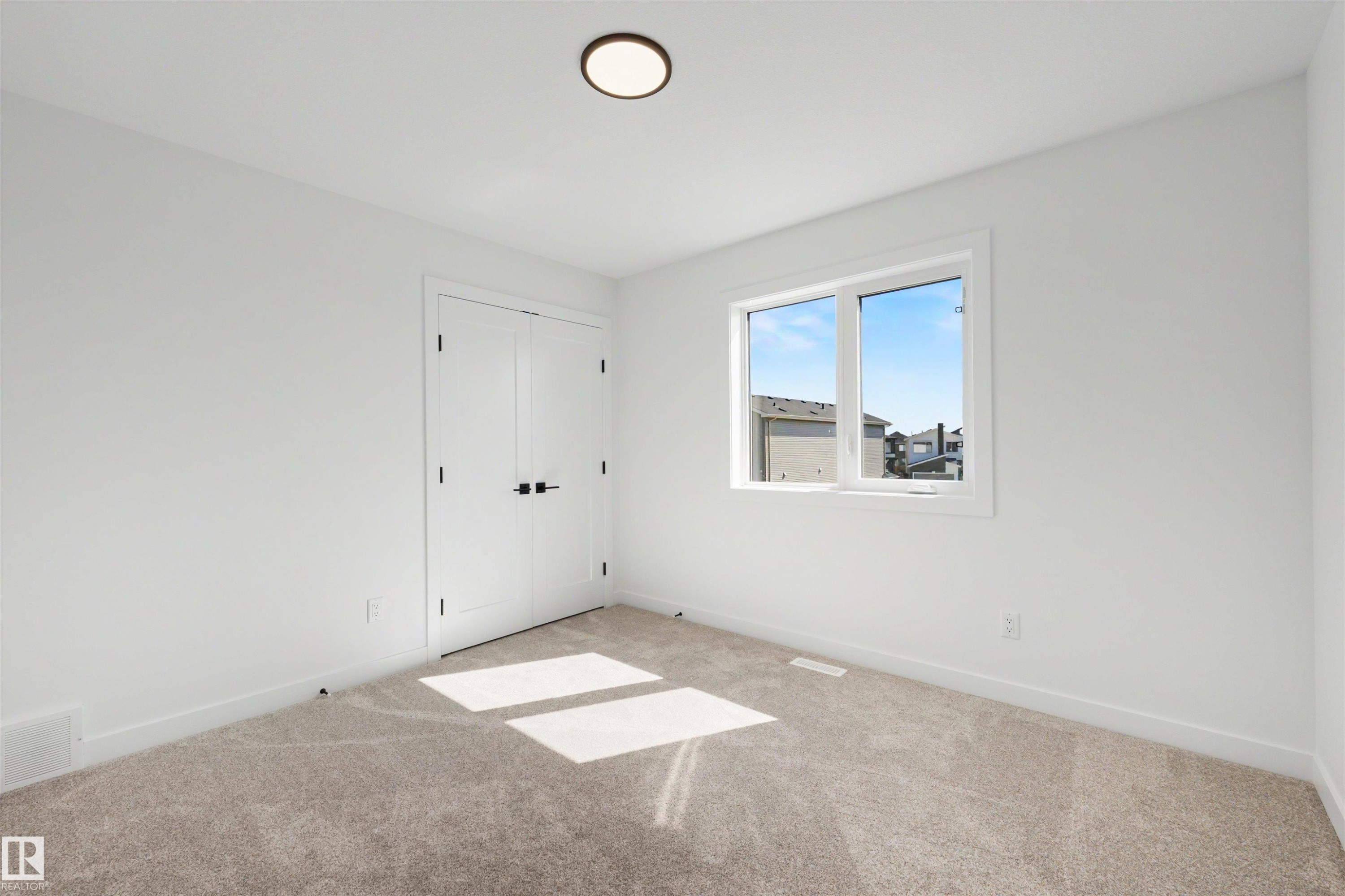 Room featuring neutral-toned carpeting and white walls with matching baseboards - 30 Elsinore Place Nw, Edmonton, AB