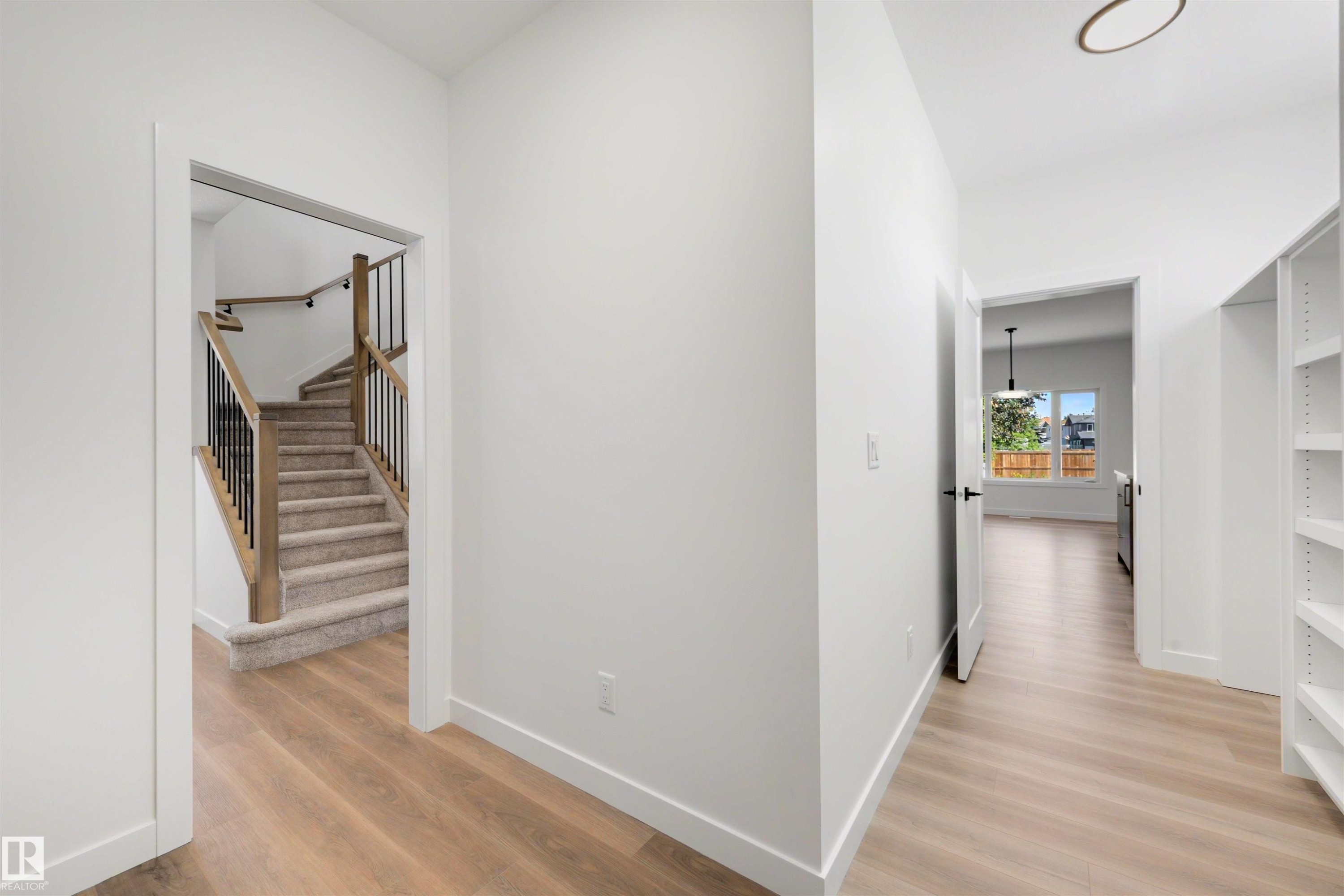 Foyer featuring light wood-finish flooring, white walls, and built-in shelving - 30 Elsinore Place Nw, Edmonton, AB