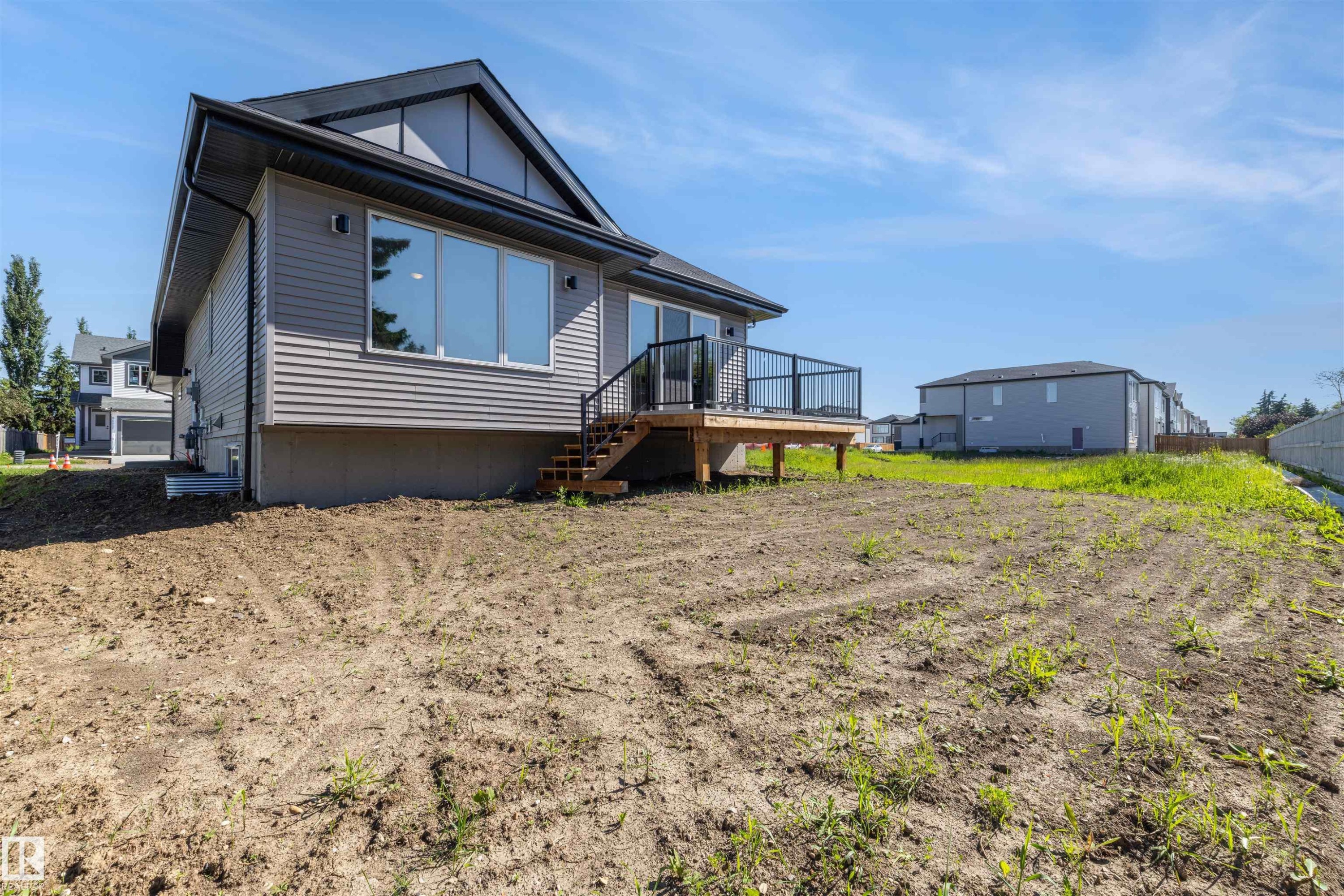 Rear exterior featuring grey horizontal siding and a dark roof - 39 Elsinore Place, Edmonton, AB