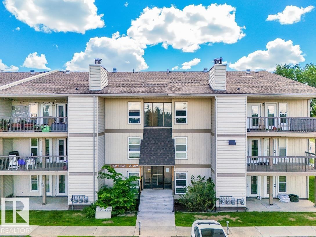 Multi-story building featuring balconies on upper levels and ground-floor patios - #301 10528 29 Av Nw, Edmonton, AB