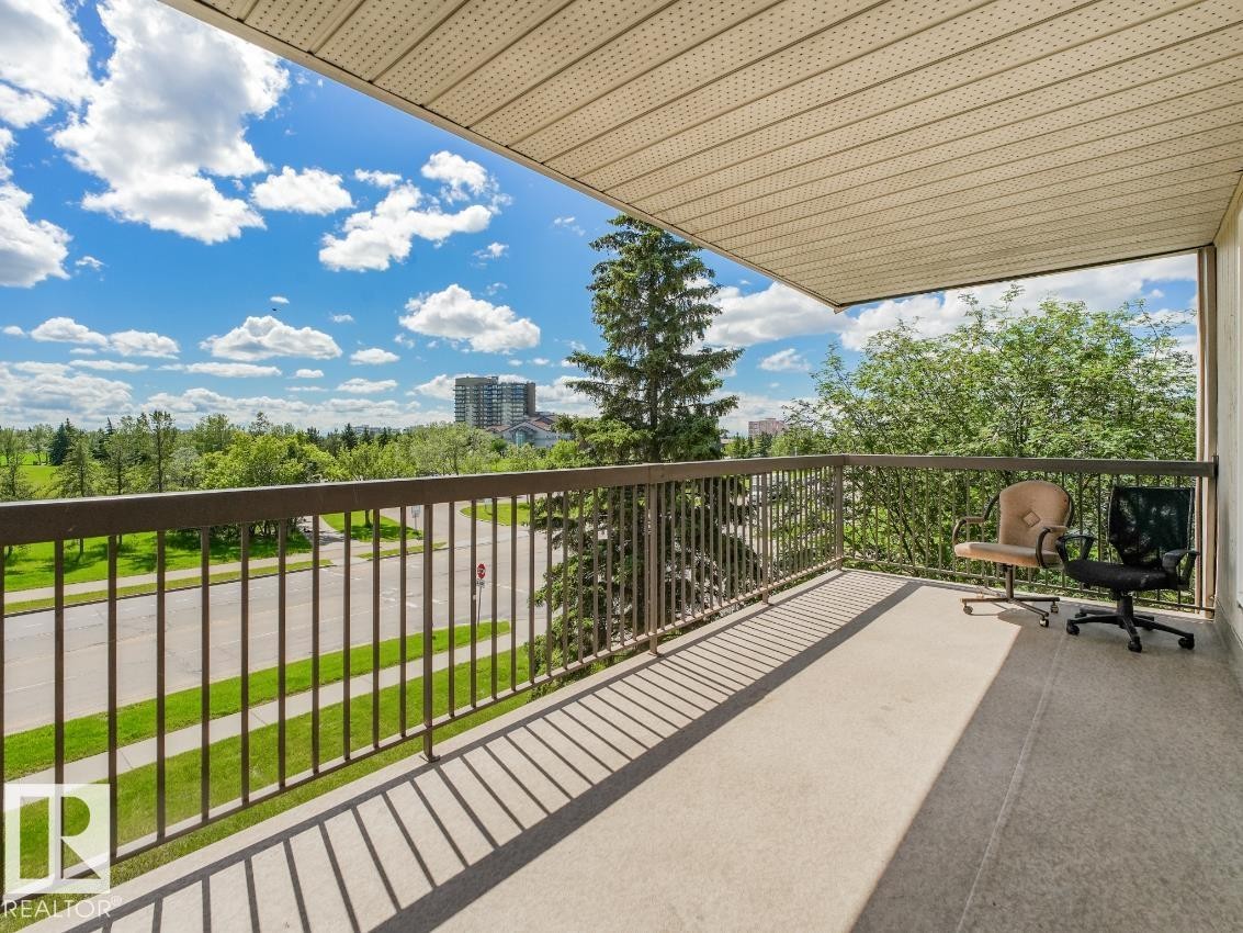 Spacious balcony featuring concrete flooring and a dark metal railing - #301 10528 29 Av Nw, Edmonton, AB