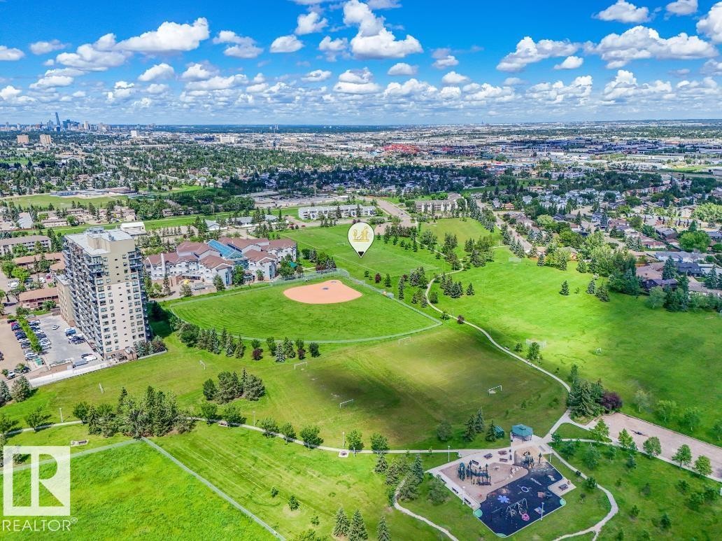 Expansive parkland setting featuring a baseball diamond, multiple open fields, and a dedicated playground area - #301 10528 29 Av Nw, Edmonton, AB