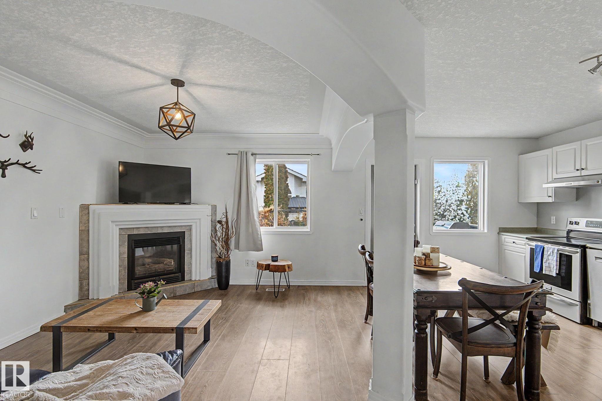 Open-concept living space with wood-finish flooring - 1619 Welbourn Cove, Edmonton, AB