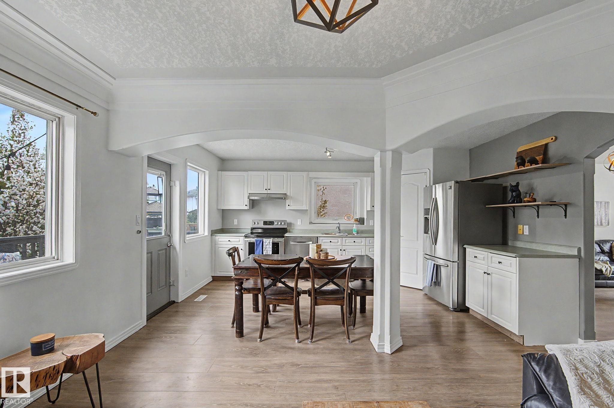 Open-concept living area featuring wood-finish flooring throughout - 1619 Welbourn Cove, Edmonton, AB