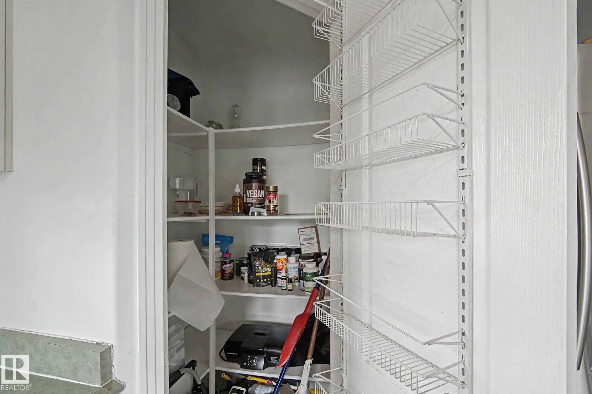 Pantry featuring white wire shelving, built-in wall shelving, and a white interior - 1619 Welbourn Cove, Edmonton, AB
