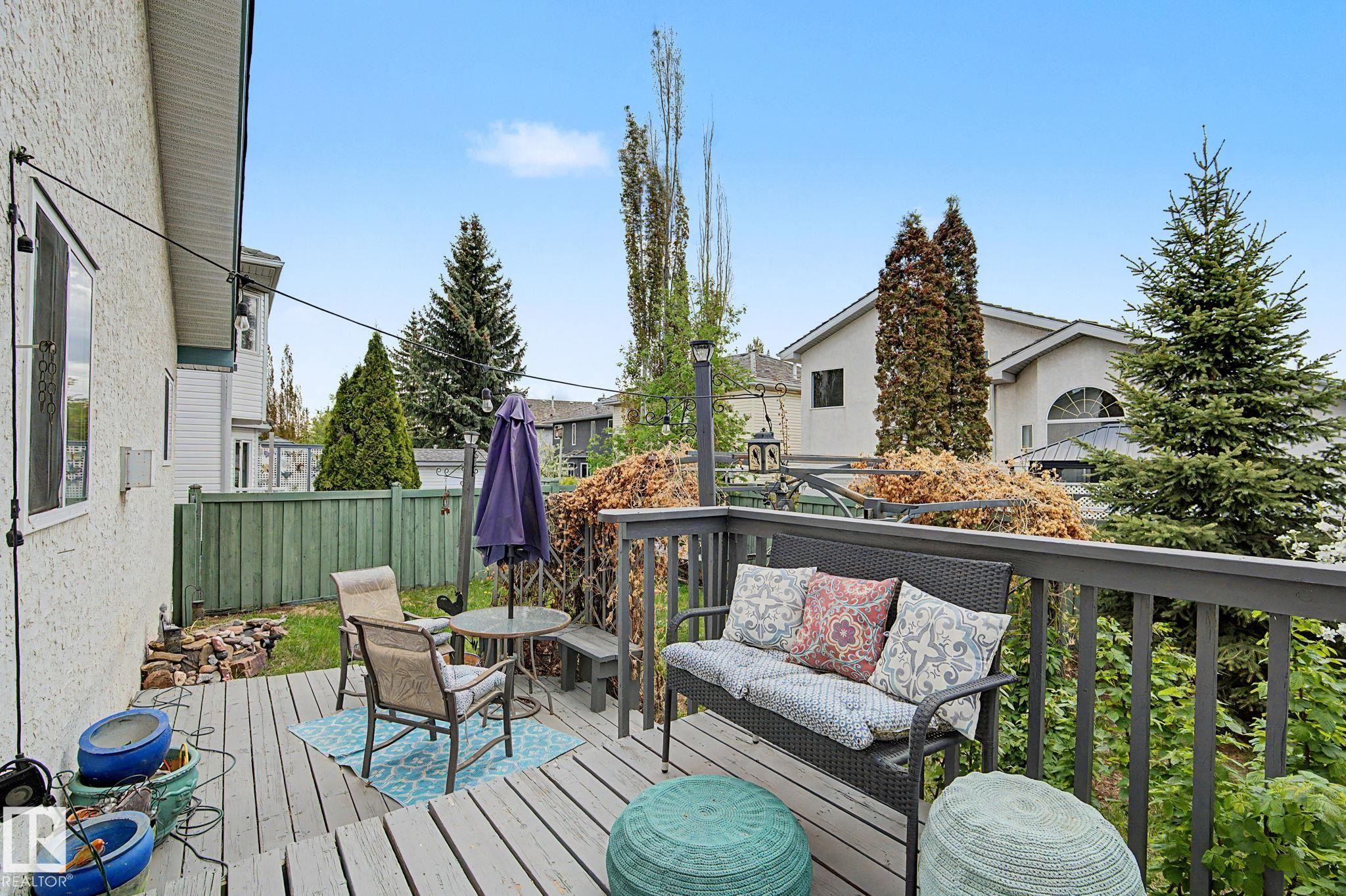 Expansive wood-finish decking featuring a built-in bench, gray railing, and privacy fencing - 1619 Welbourn Cove, Edmonton, AB