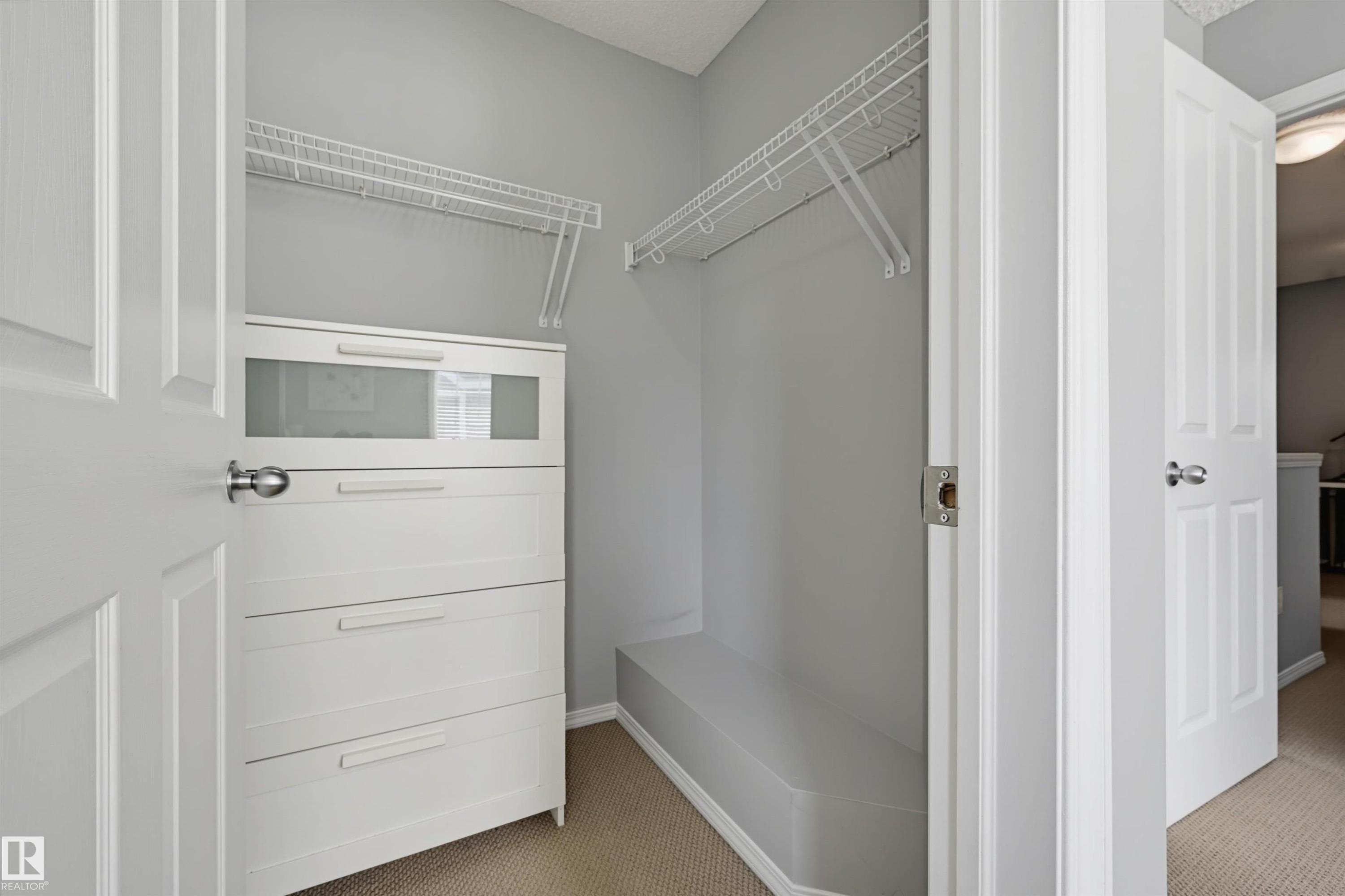 Walk-in closet featuring built-in cabinetry, wire shelving, and carpeting - 126 2051 Towne Centre Boulevard, Edmonton, AB