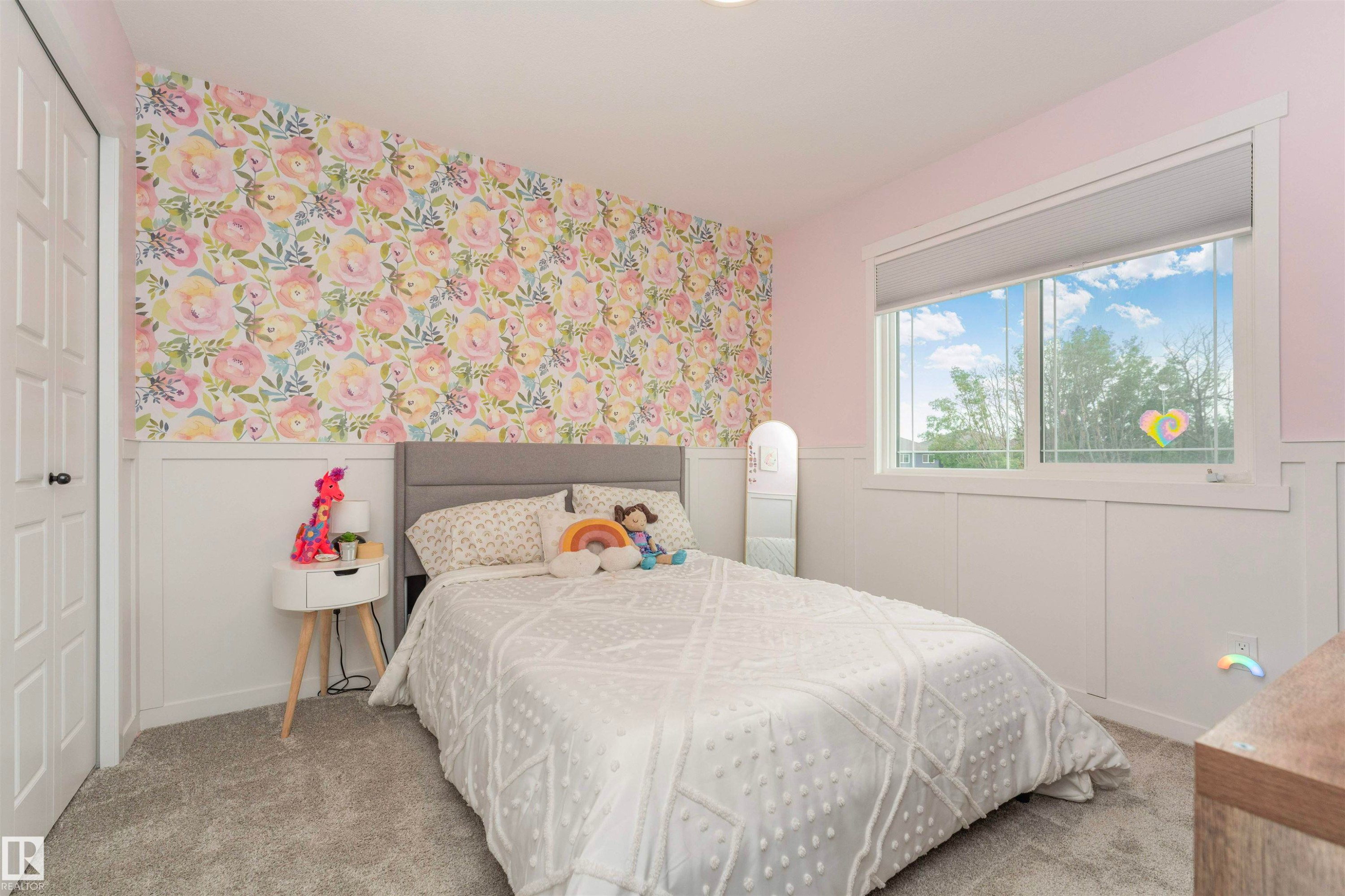 Room featuring a floral accent wall, white wainscoting, and gray carpeting - 102 Horton Way, Ardrossan, AB