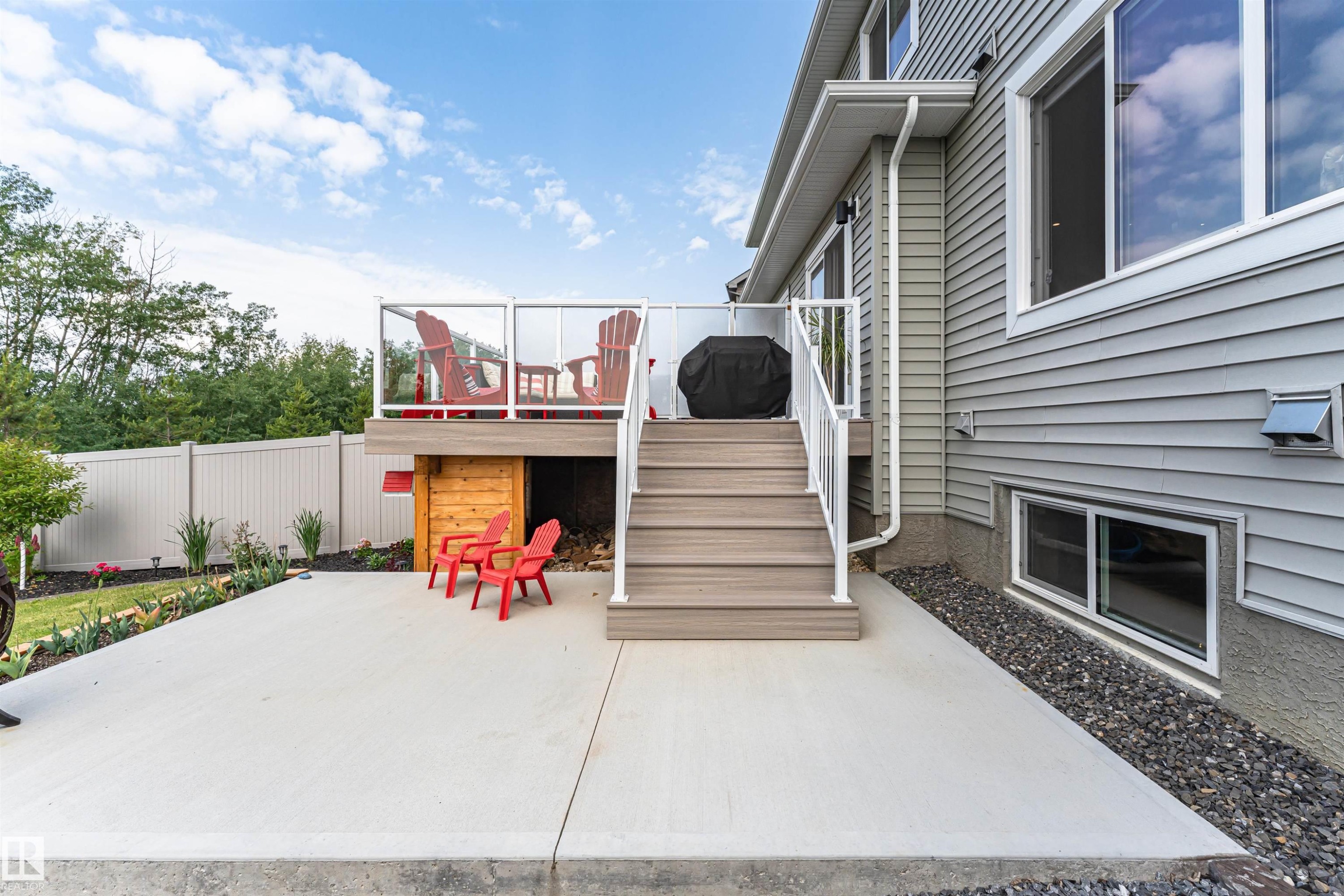 Rear exterior featuring a multi-level deck with glass panel railing and composite decking - 102 Horton Way, Ardrossan, AB