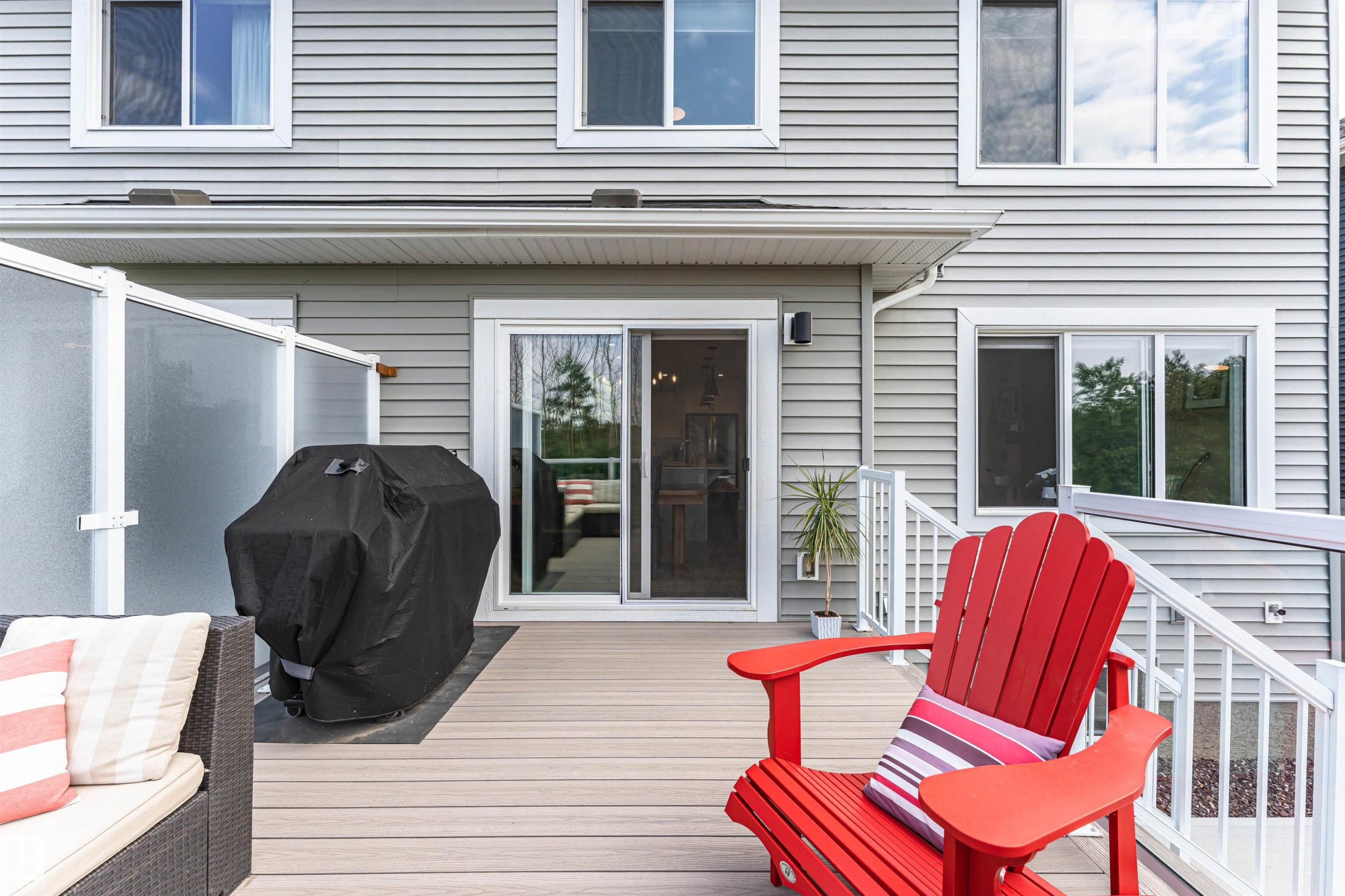 Spacious composite deck with white railing and privacy screen - 102 Horton Way, Ardrossan, AB