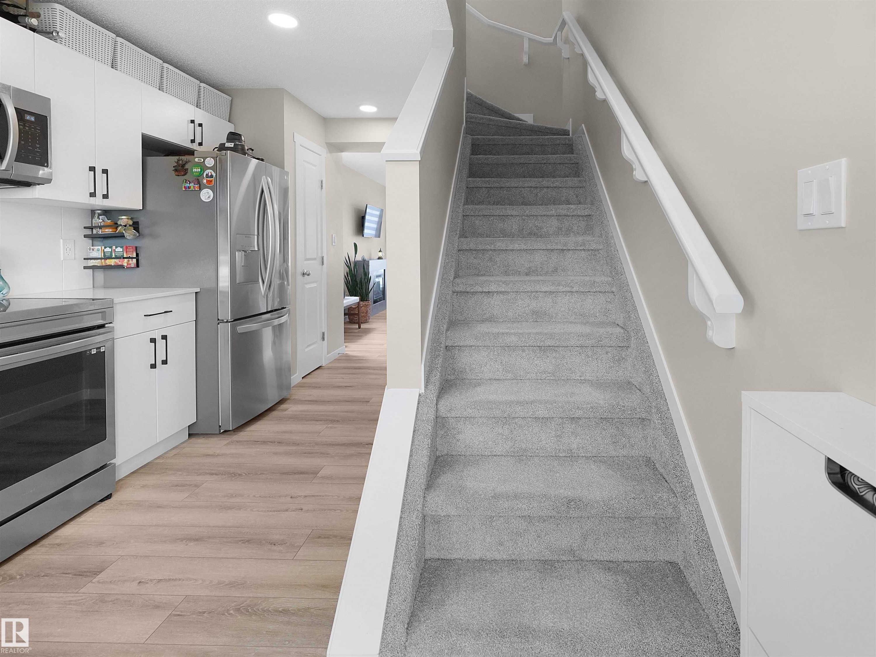 Staircase with gray carpeted treads and white handrails - #49 17832 78 St Nw, Edmonton, AB - Indoor Photo Showing Other Room
