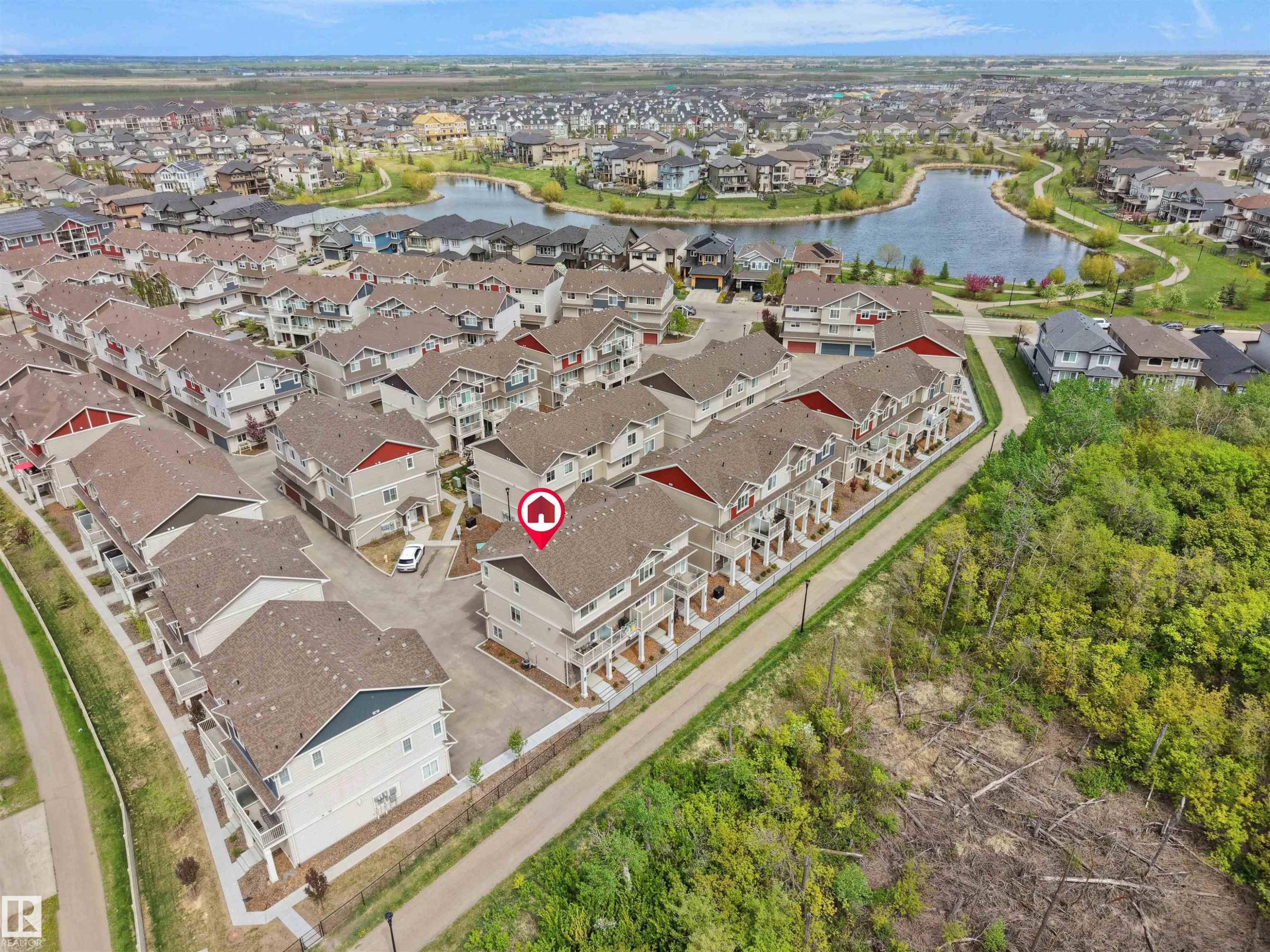 Aerial perspective highlighting a residential community with a central lake feature - #49 17832 78 St Nw, Edmonton, AB - Outdoor With View