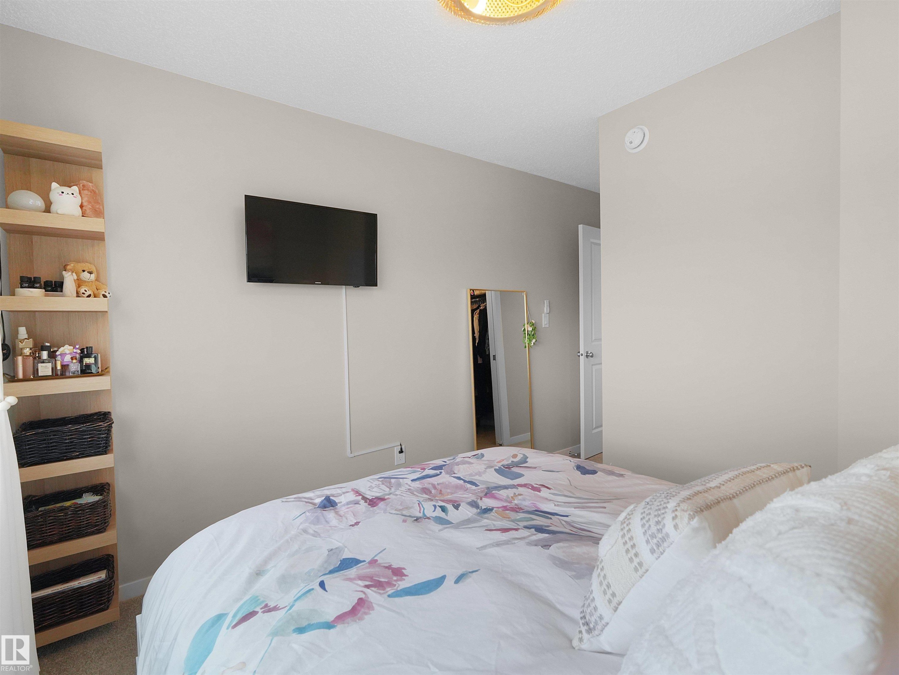 Wall-mounted television with discreet cable management - #49 17832 78 St Nw, Edmonton, AB - Indoor Photo Showing Bedroom