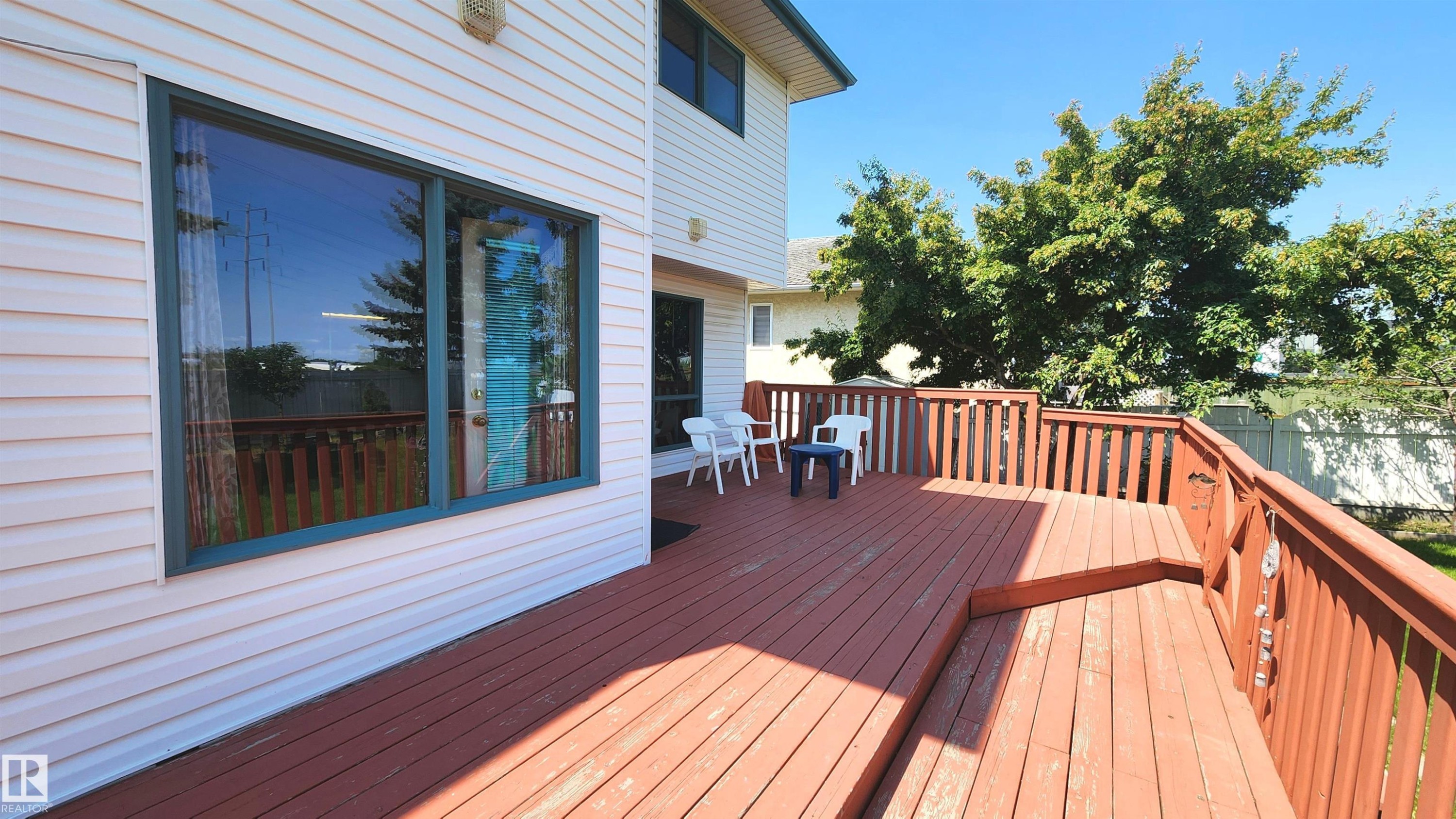 Spacious wood deck with perimeter railing and integrated steps - 2708 44A Avenue, Edmonton, AB