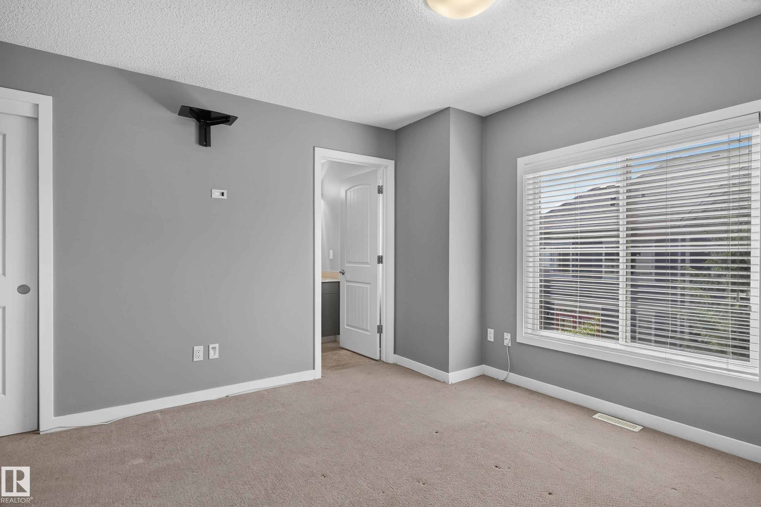 Interior room featuring light grey walls, carpet flooring, and white trim - 24 655 Watt Boulevard, Edmonton, AB
