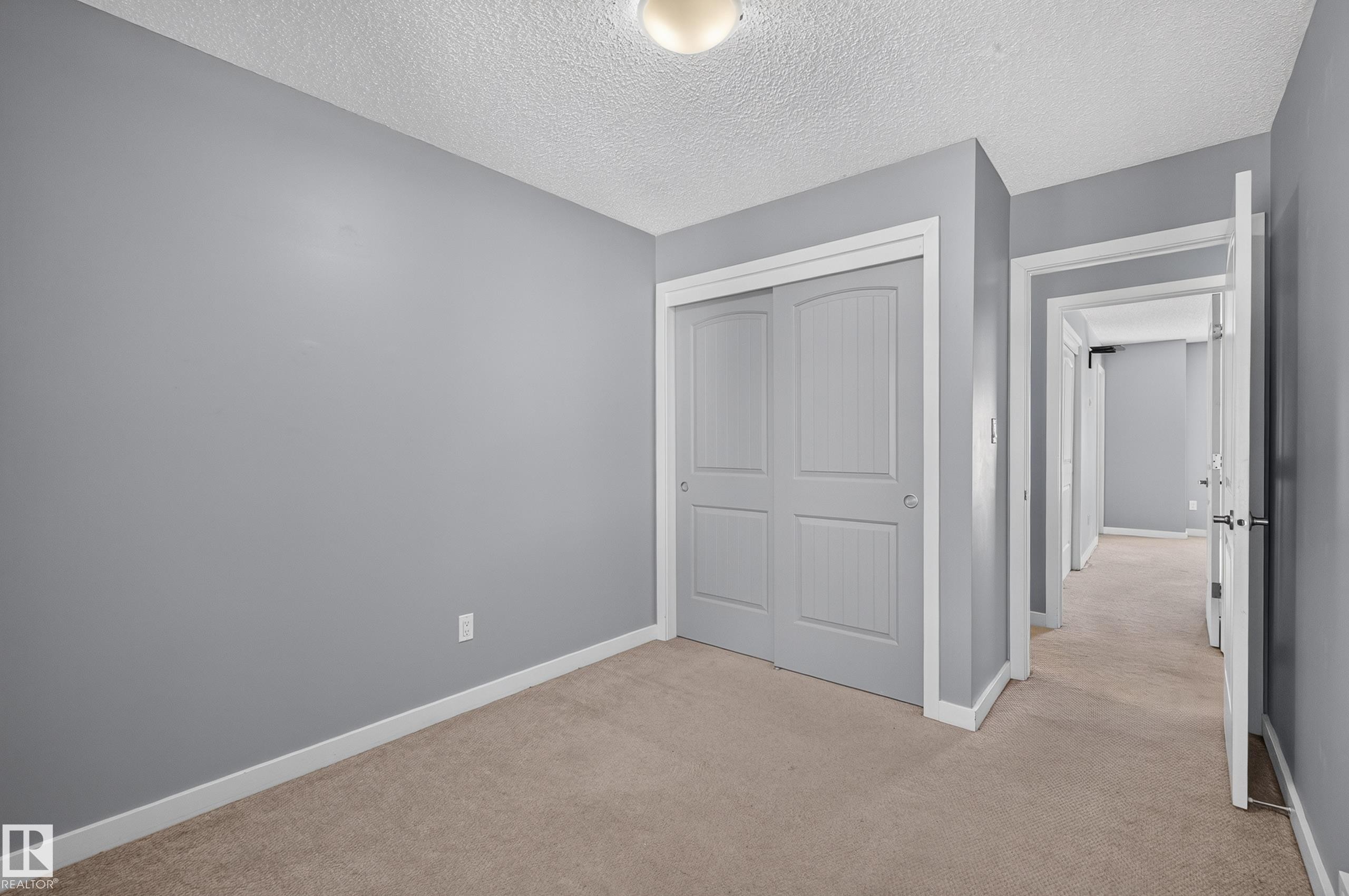 Room featuring neutral-toned carpet, light gray wall paint, and white trim - 24 655 Watt Boulevard, Edmonton, AB