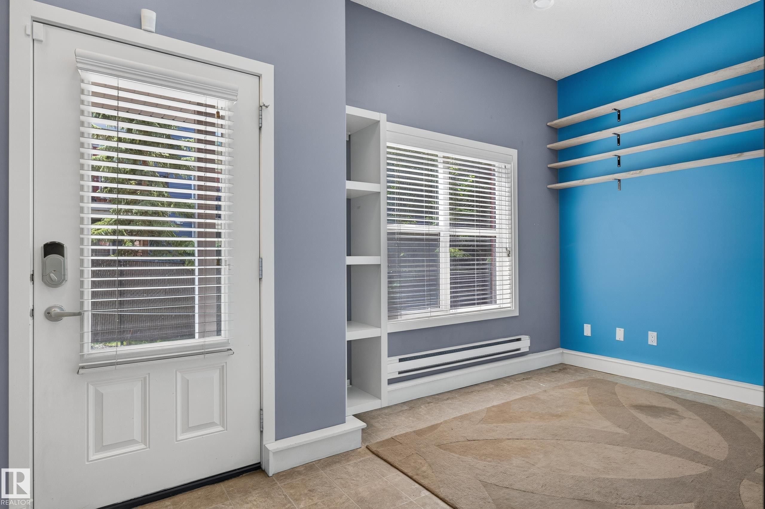 Entryway featuring a white door with a window and integrated blinds, a digital lock, and a built-in shelving unit - 24 655 Watt Boulevard, Edmonton, AB