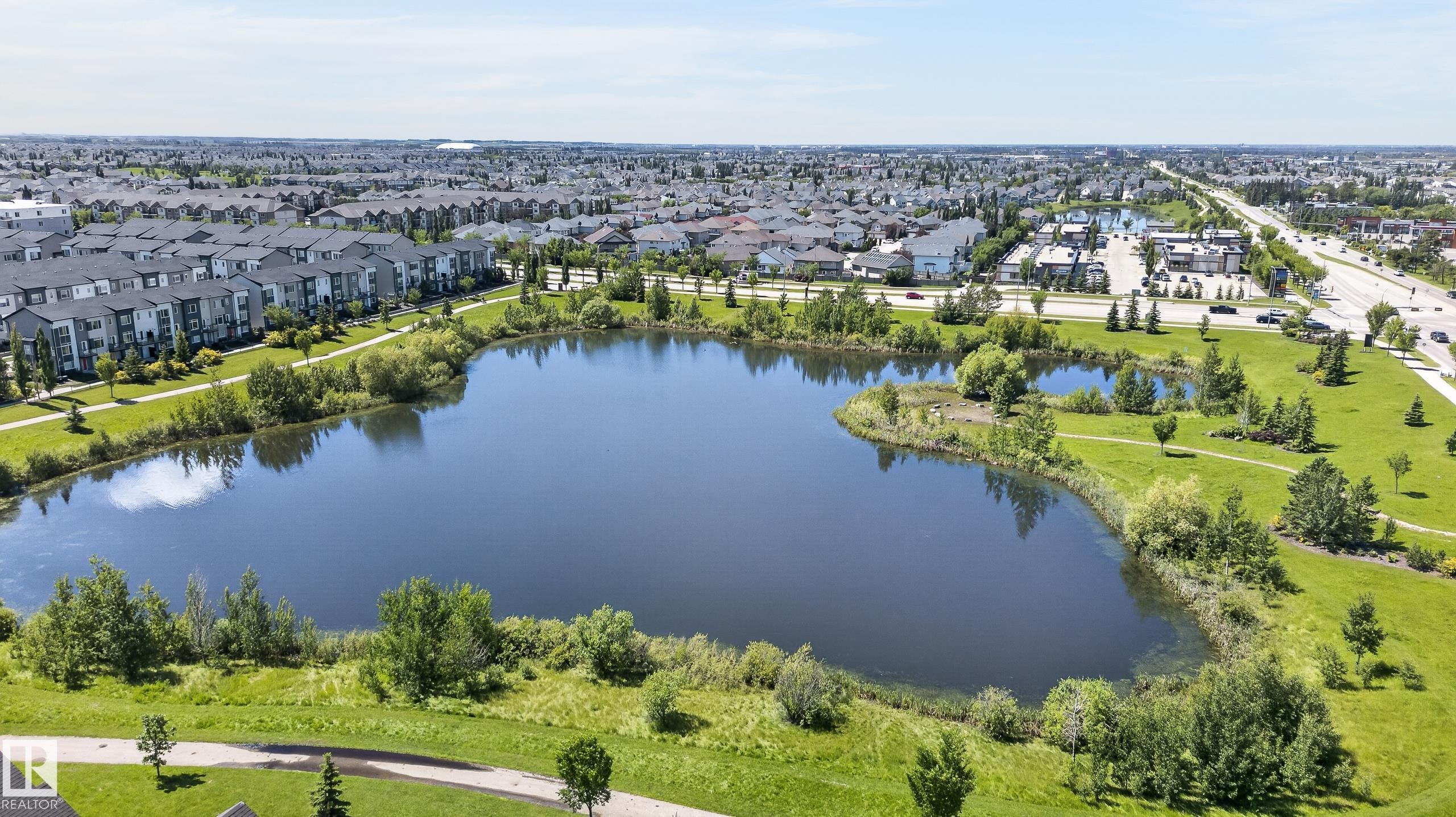 Community featuring a substantial central pond surrounded by green spaces and paved pathways - 24 655 Watt Boulevard, Edmonton, AB