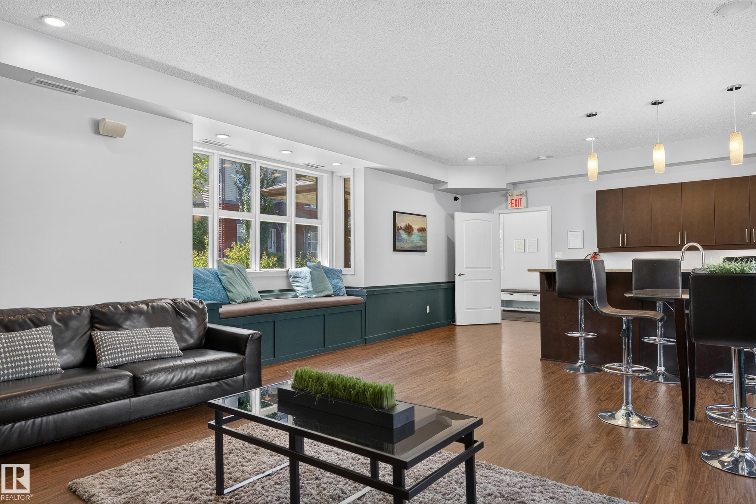 Open-concept living area featuring wood-finish flooring, recessed lighting, and a built-in window bench - 24 655 Watt Boulevard, Edmonton, AB