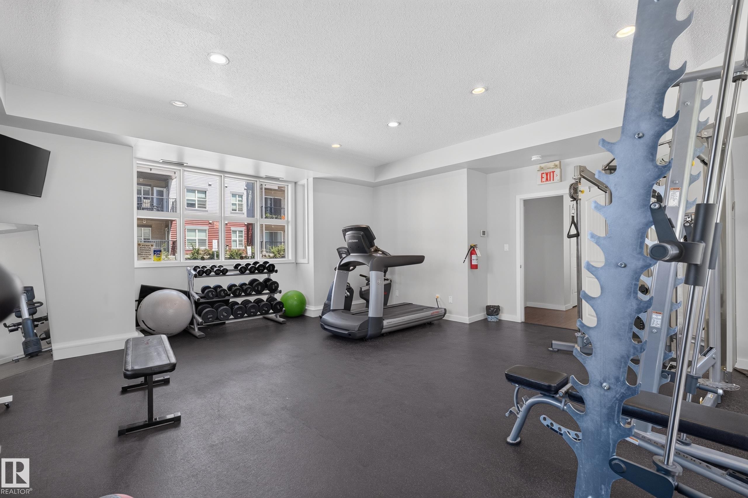 Dedicated fitness room featuring recessed lighting, a large multi-pane window, and durable dark flooring - 24 655 Watt Boulevard, Edmonton, AB