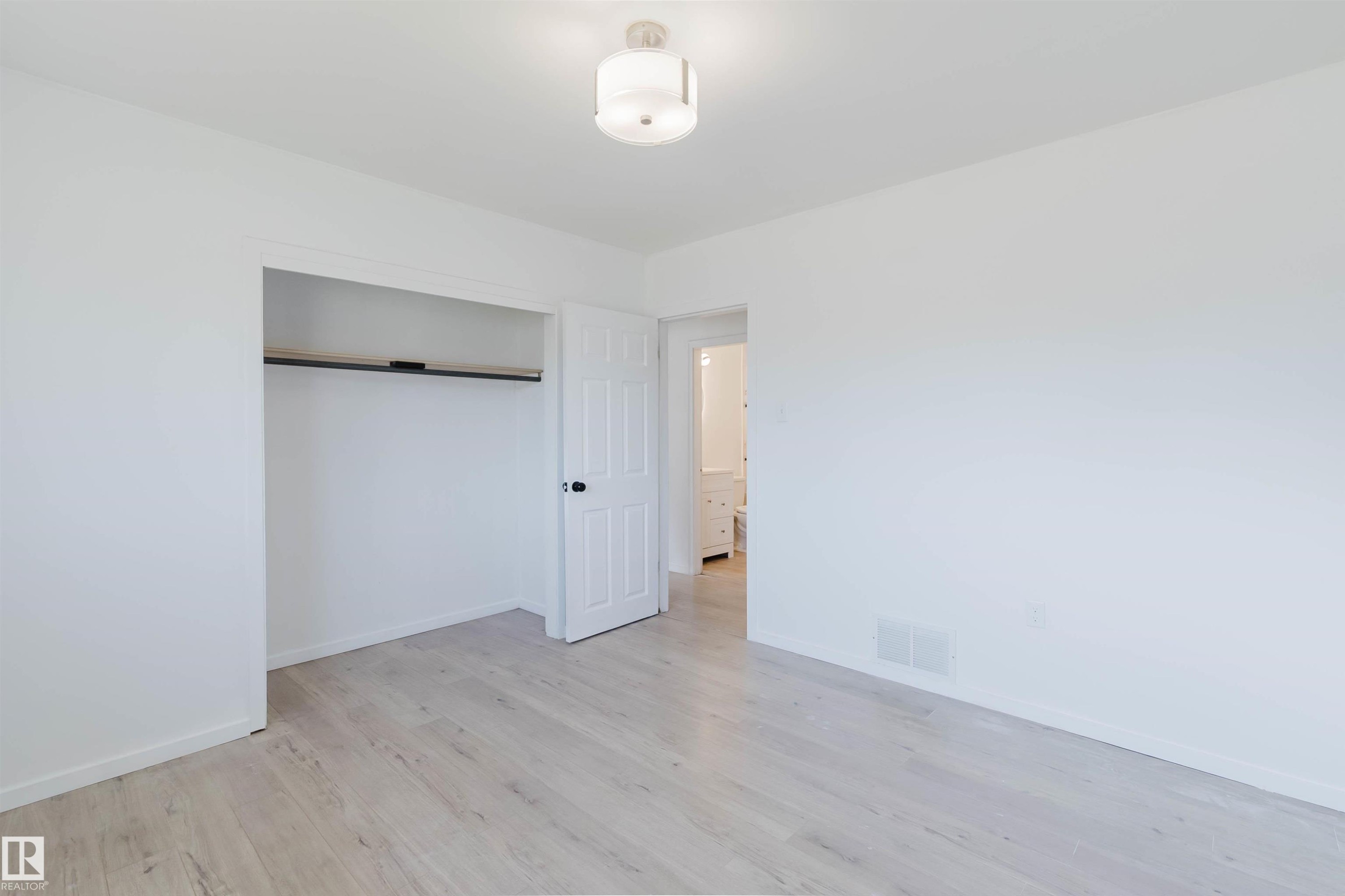 Room featuring light wood-finish flooring, white walls, and a semi-flush mount ceiling fixture - 9606 163 Street Nw, Edmonton, AB
