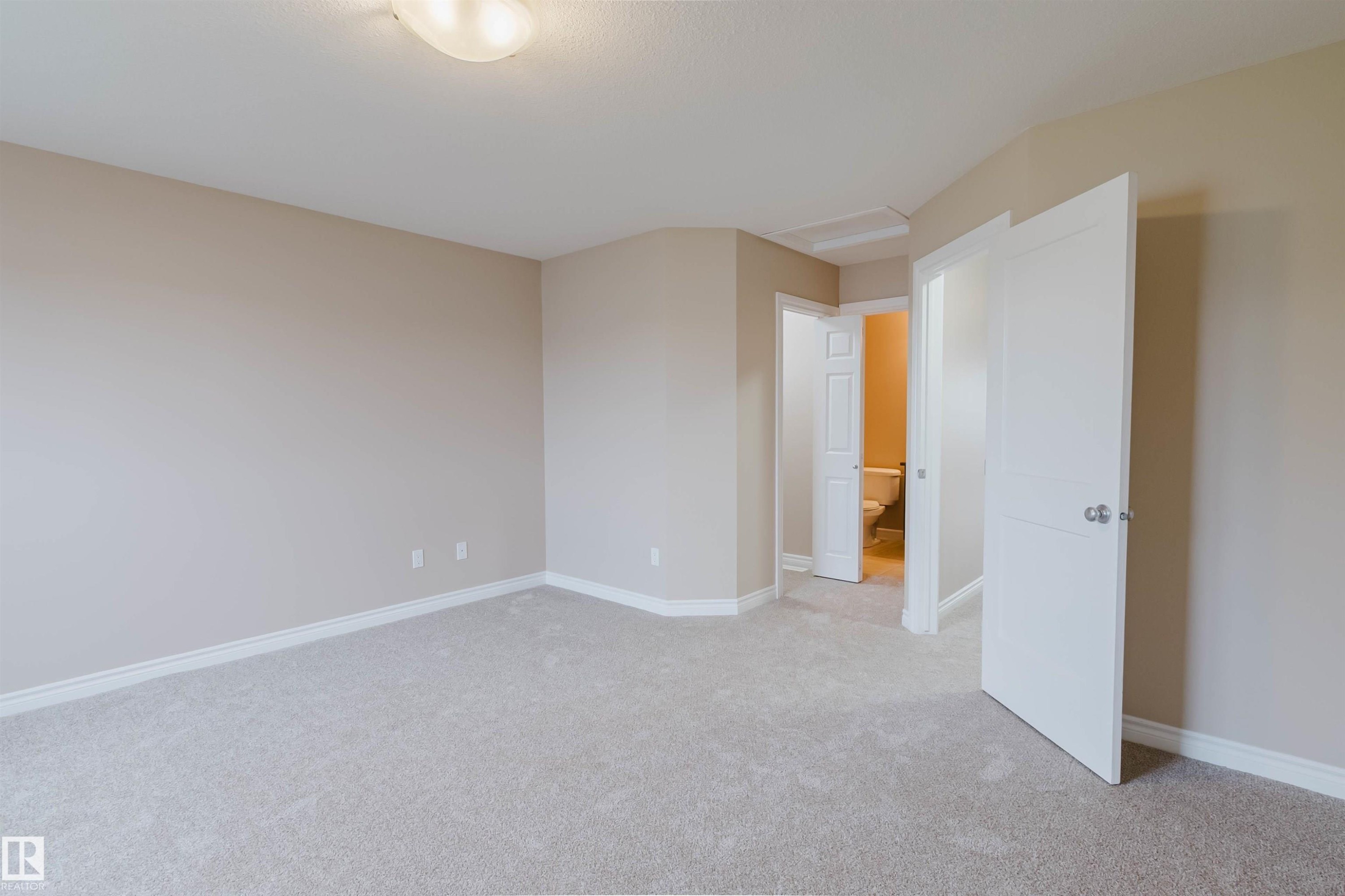 Spacious room featuring light-colored carpeting and neutral wall paint - 1919 Hammond Place, Edmonton, AB