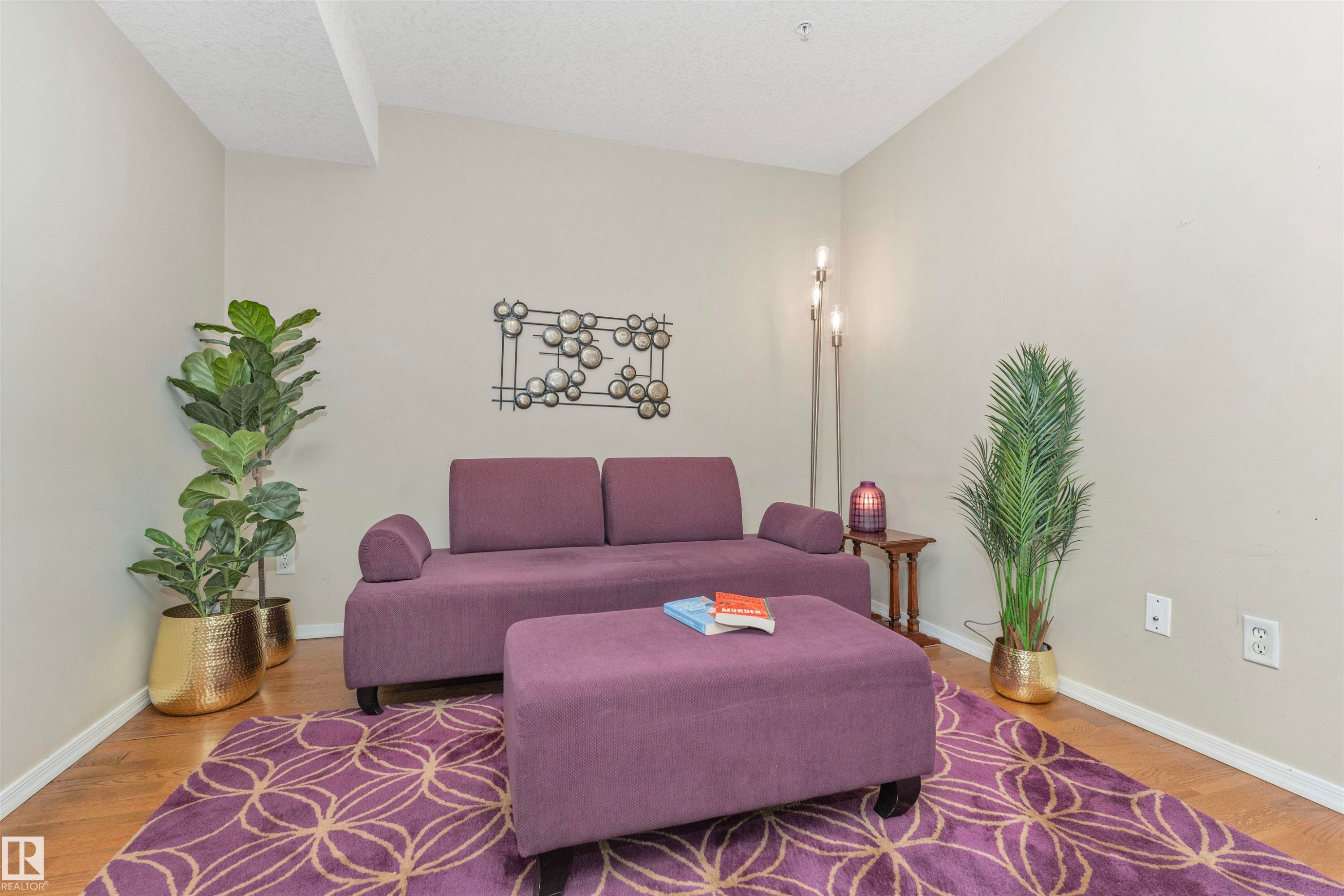 Neutral wall paint with white trim, wood-finish flooring, and a vaulted ceiling - #130 9008 99 Av Nw Nw, Edmonton, AB
