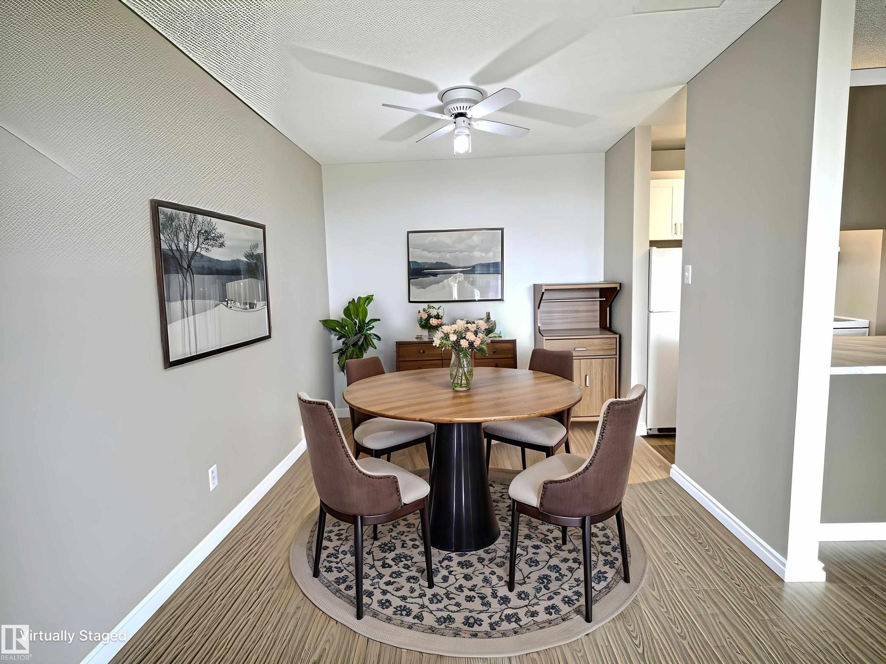 Dining area featuring wood-finish flooring, light grey walls, and a ceiling fan with integrated lighting - 1105 11007 83 Avenue, Edmonton, AB