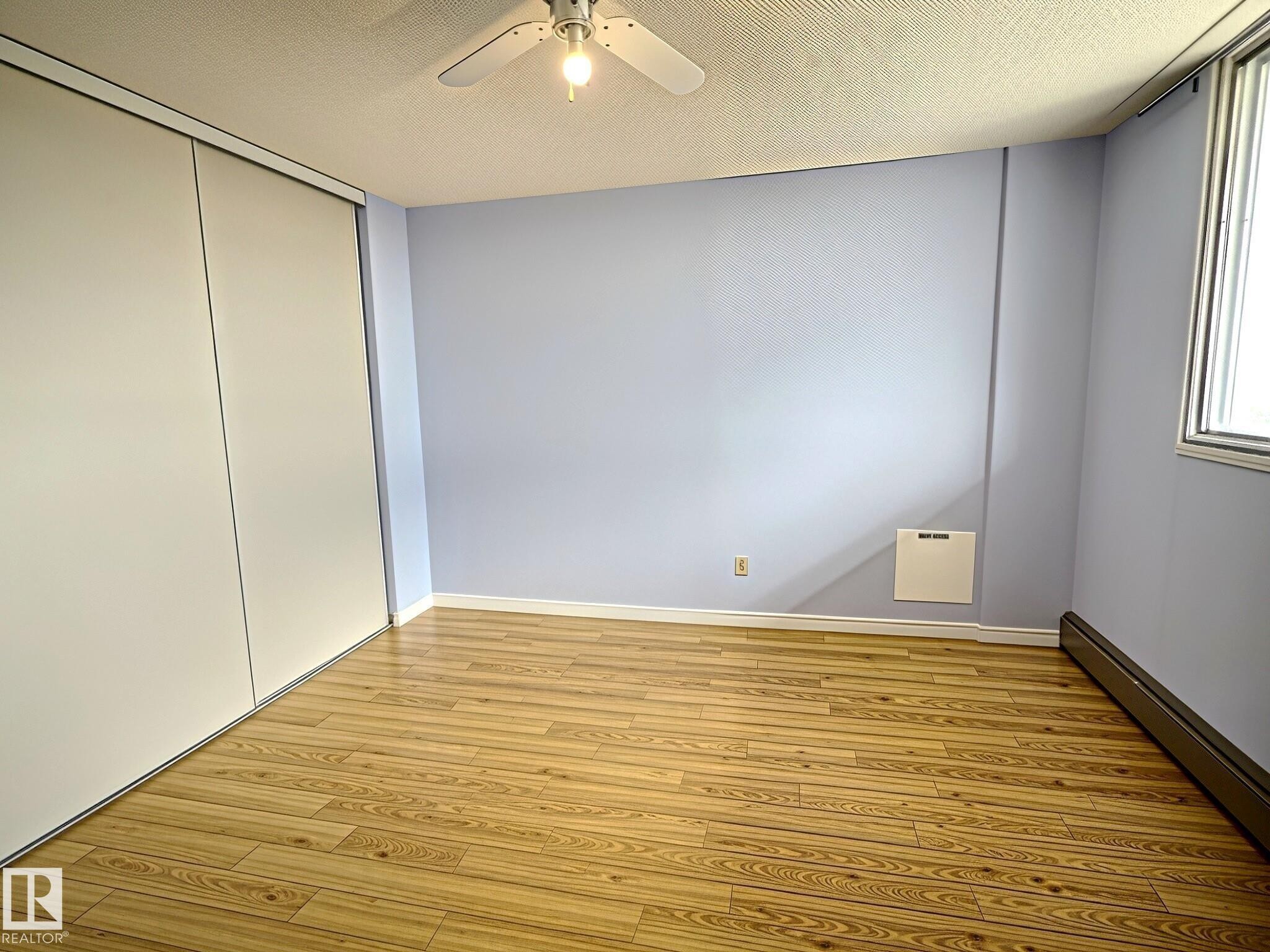 Light wood-finish flooring complements soft blue walls - 1105 11007 83 Avenue, Edmonton, AB