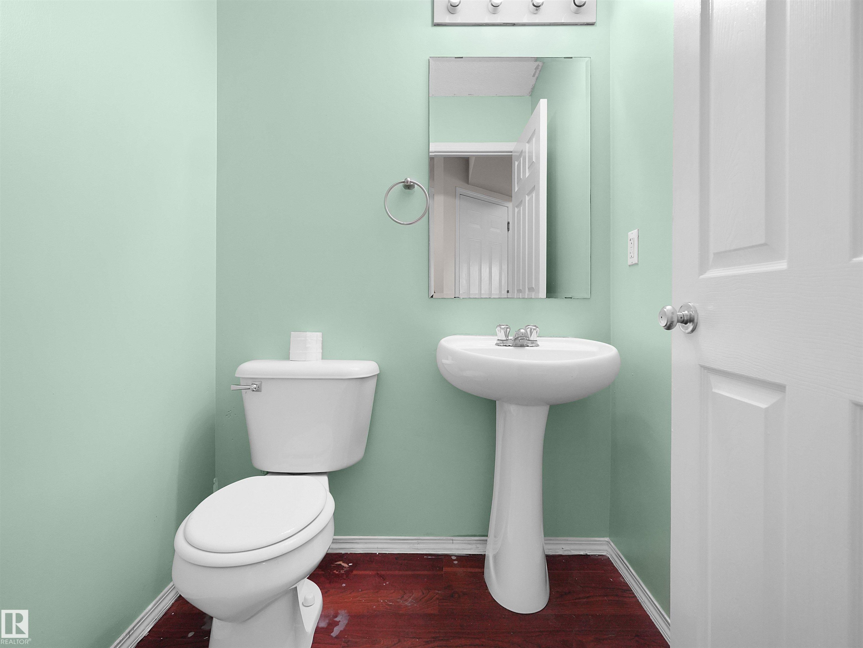 Pedestal sink with chrome fixtures and an overhead vanity light bar - 16106 131A Street Nw, Edmonton, AB - Indoor Photo Showing Bathroom