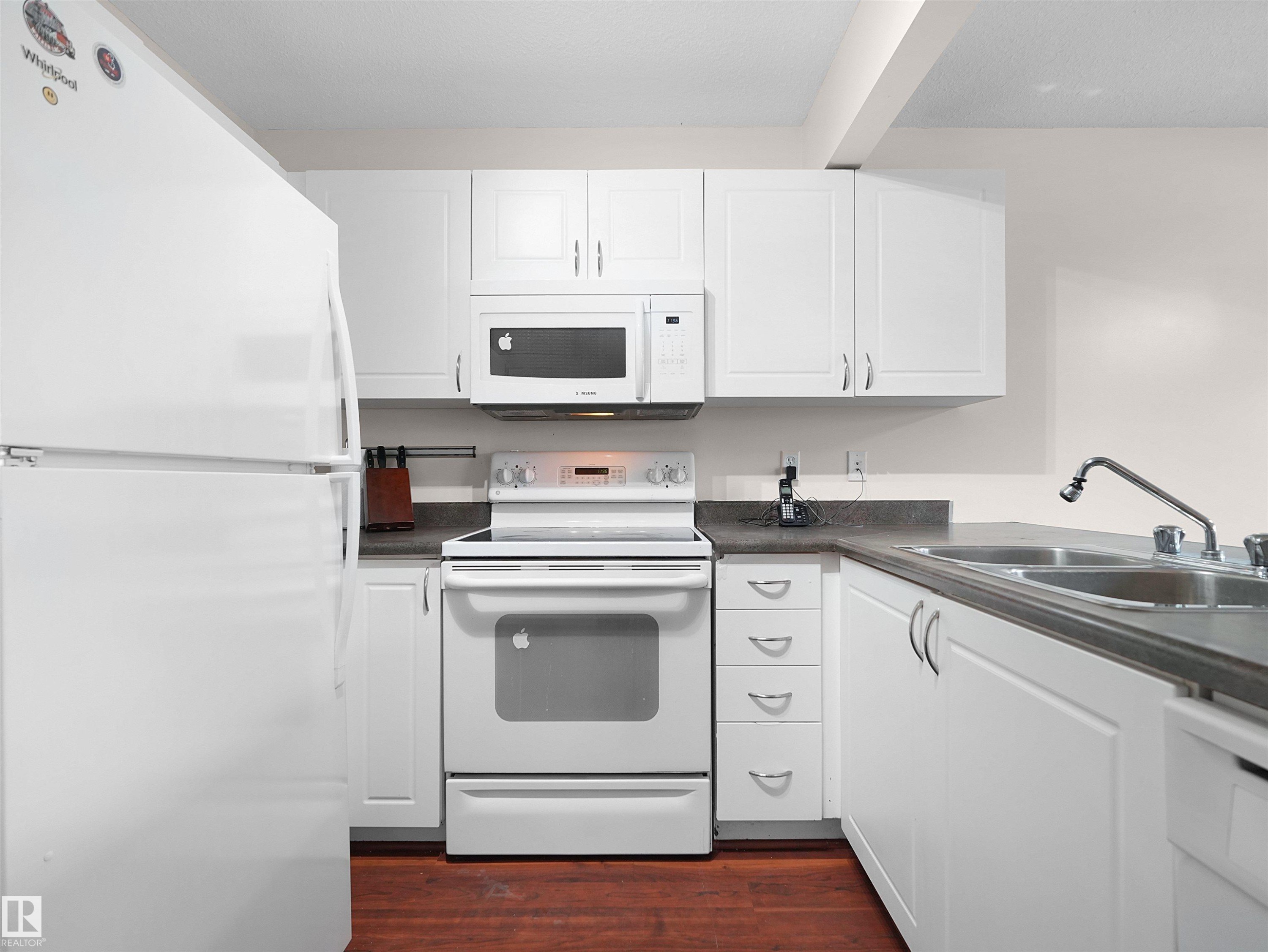 Bright kitchen featuring white cabinetry and appliances - 16106 131A Street Nw, Edmonton, AB - Indoor Photo Showing Kitchen With Double Sink