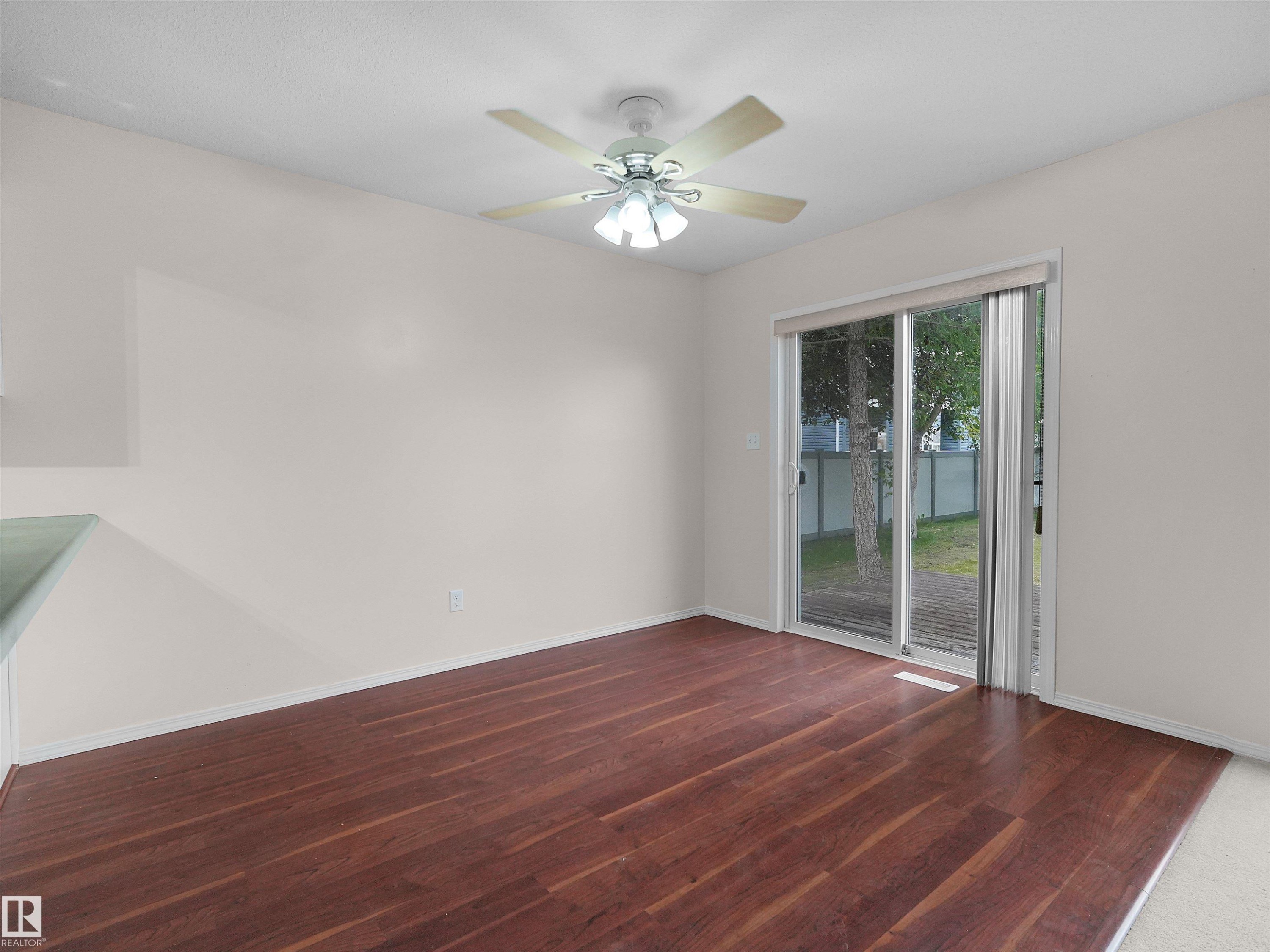 Spacious interior featuring wood-finish flooring, a ceiling fan with integrated lighting, and light-toned walls - 16106 131A Street Nw, Edmonton, AB - Indoor Photo Showing Other Room