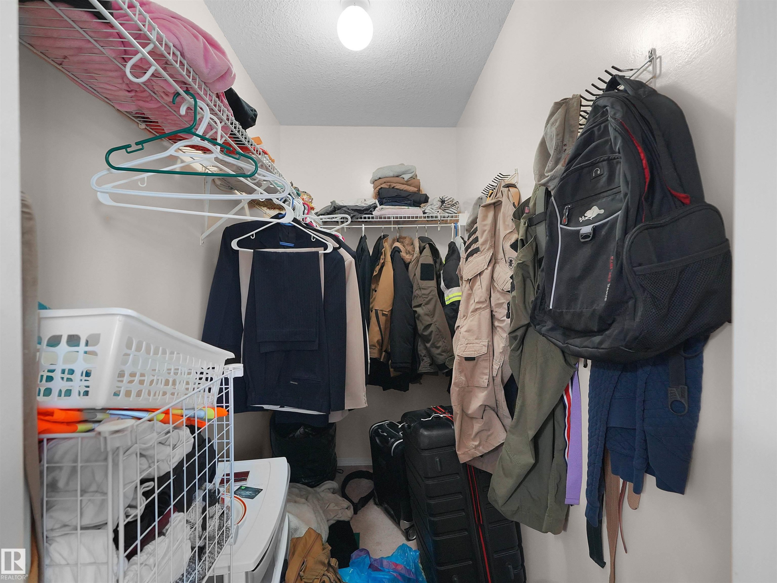 Walk-in closet with wire shelving system and overhead lighting - 16106 131A Street Nw, Edmonton, AB - Indoor With Storage