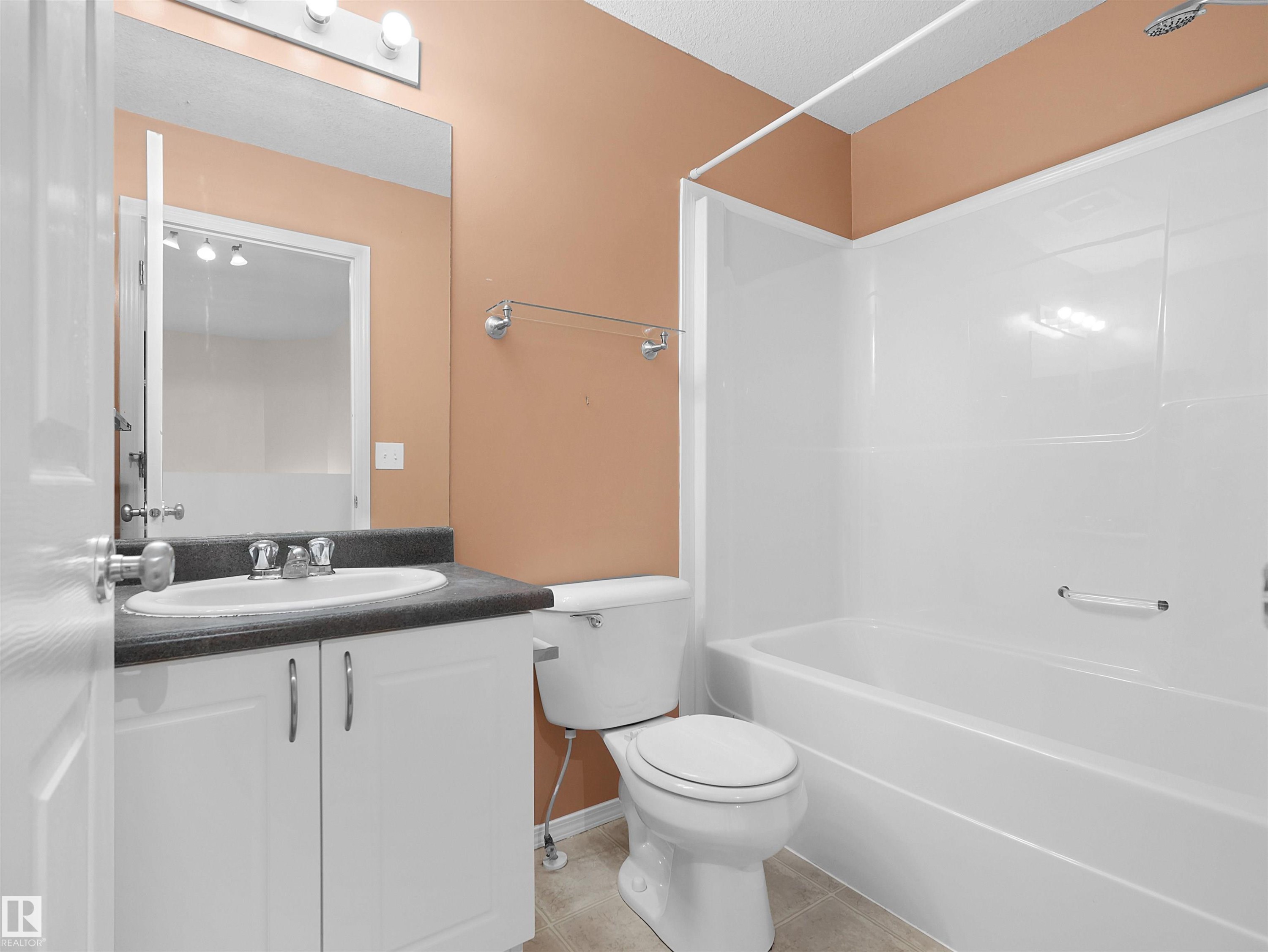 Bathroom with white vanity cabinetry, dark countertop, and a white integrated sink - 16106 131A Street Nw, Edmonton, AB - Indoor Photo Showing Bathroom