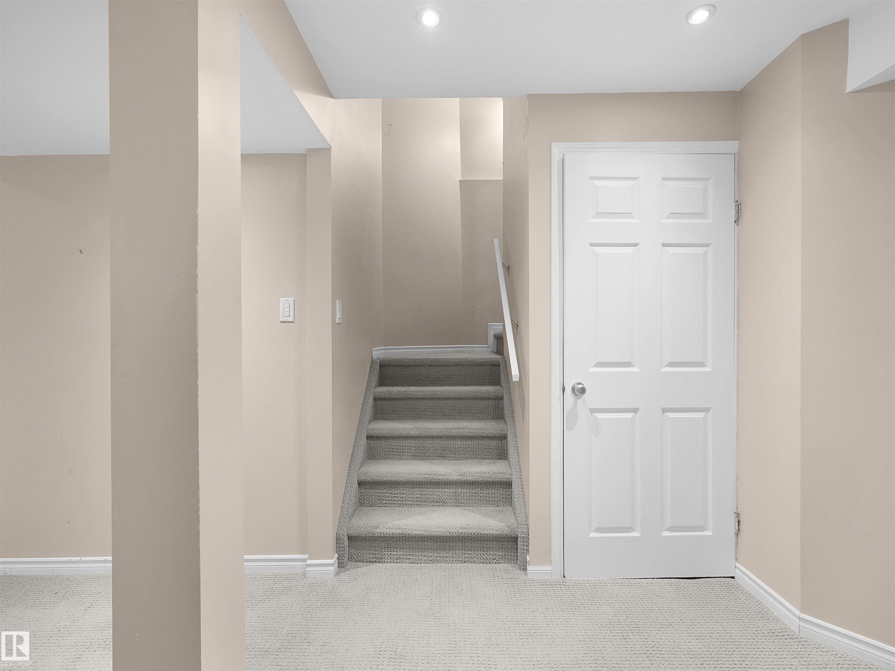 Carpeted staircase with white handrail and surrounding neutral-toned walls - 16106 131A Street Nw, Edmonton, AB - Indoor Photo Showing Other Room