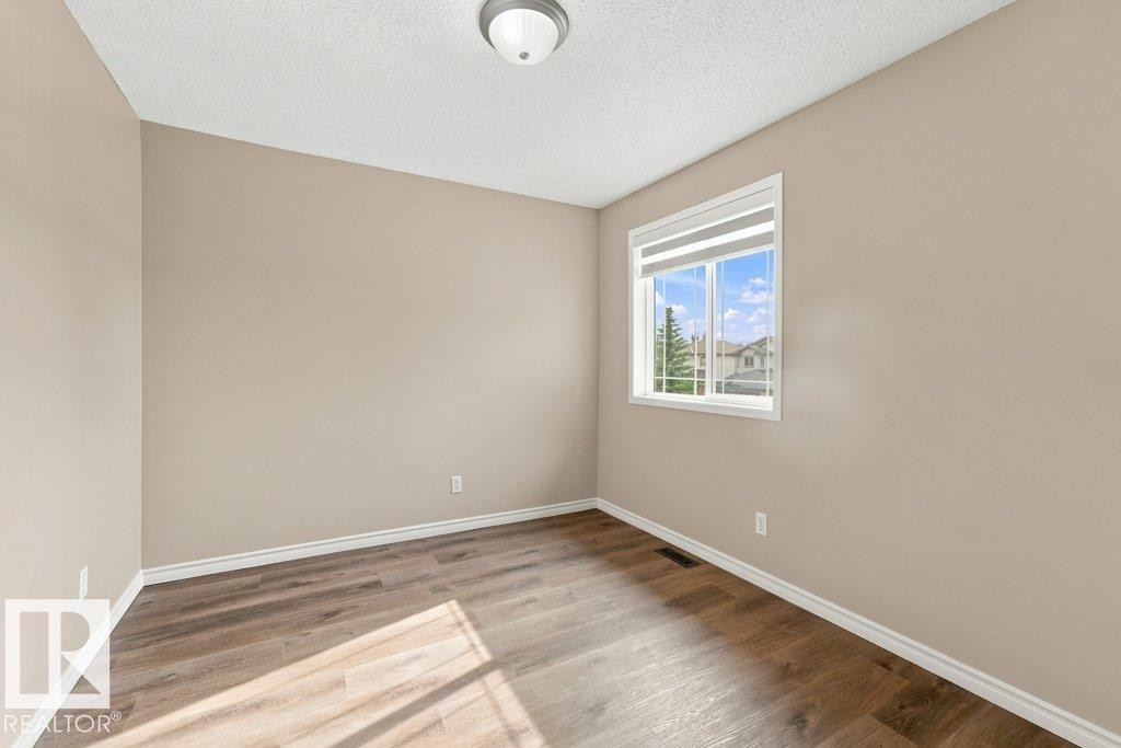 Neutral wall tones complemented by wood-finish flooring - 2811 33 Street, Edmonton, AB